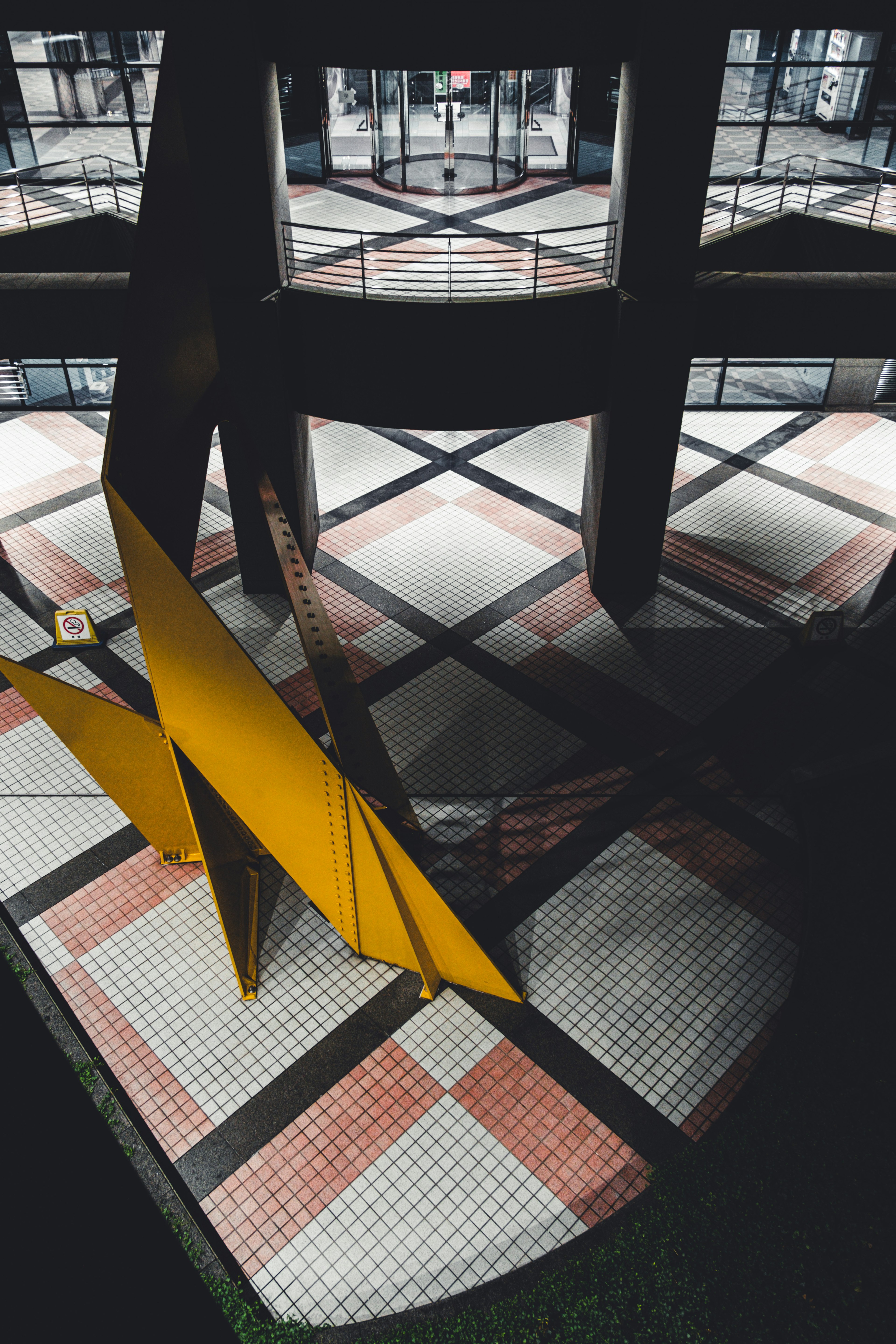 Yellow sculpture in a black space with mosaic floor