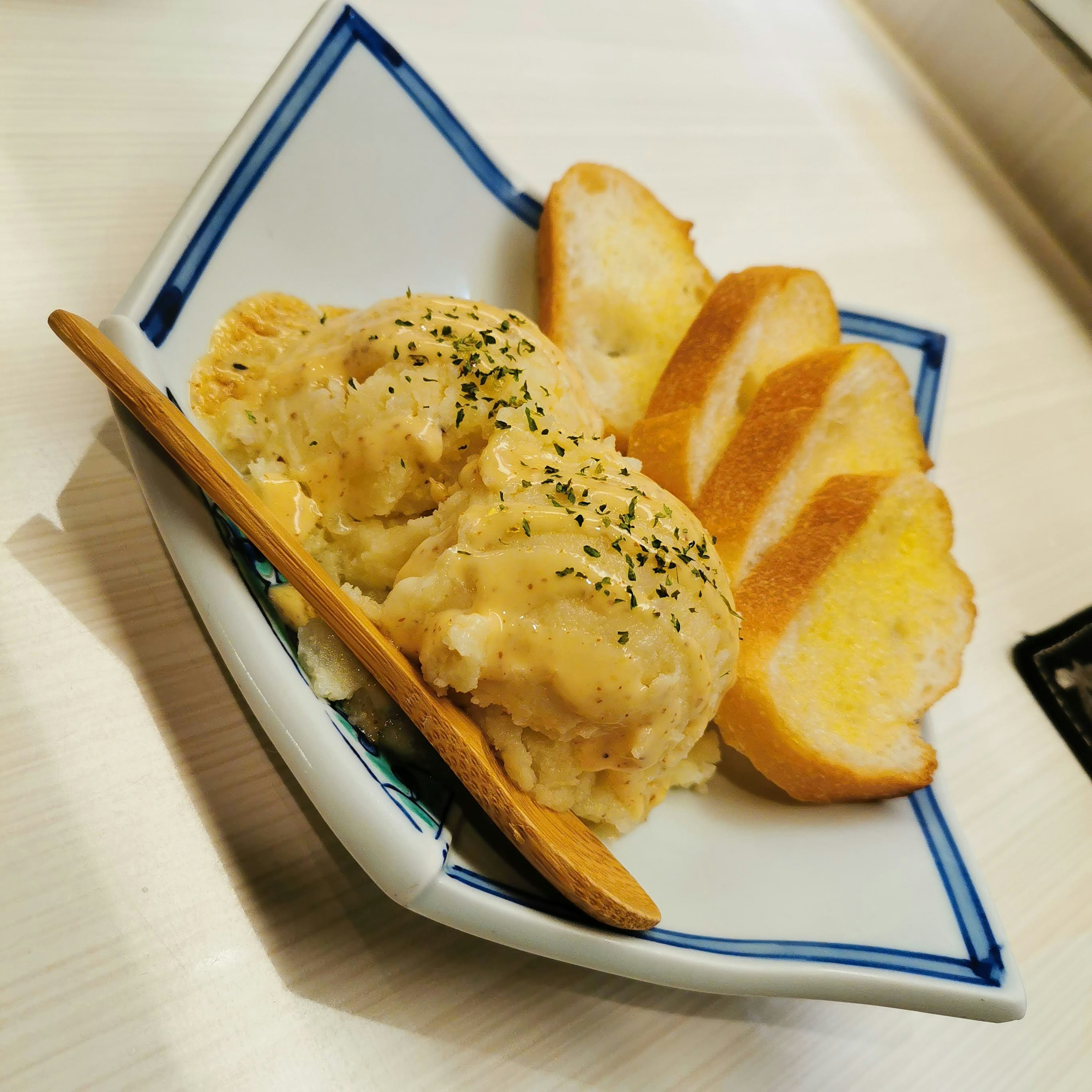 A plate with creamy dish and slices of toasted bread