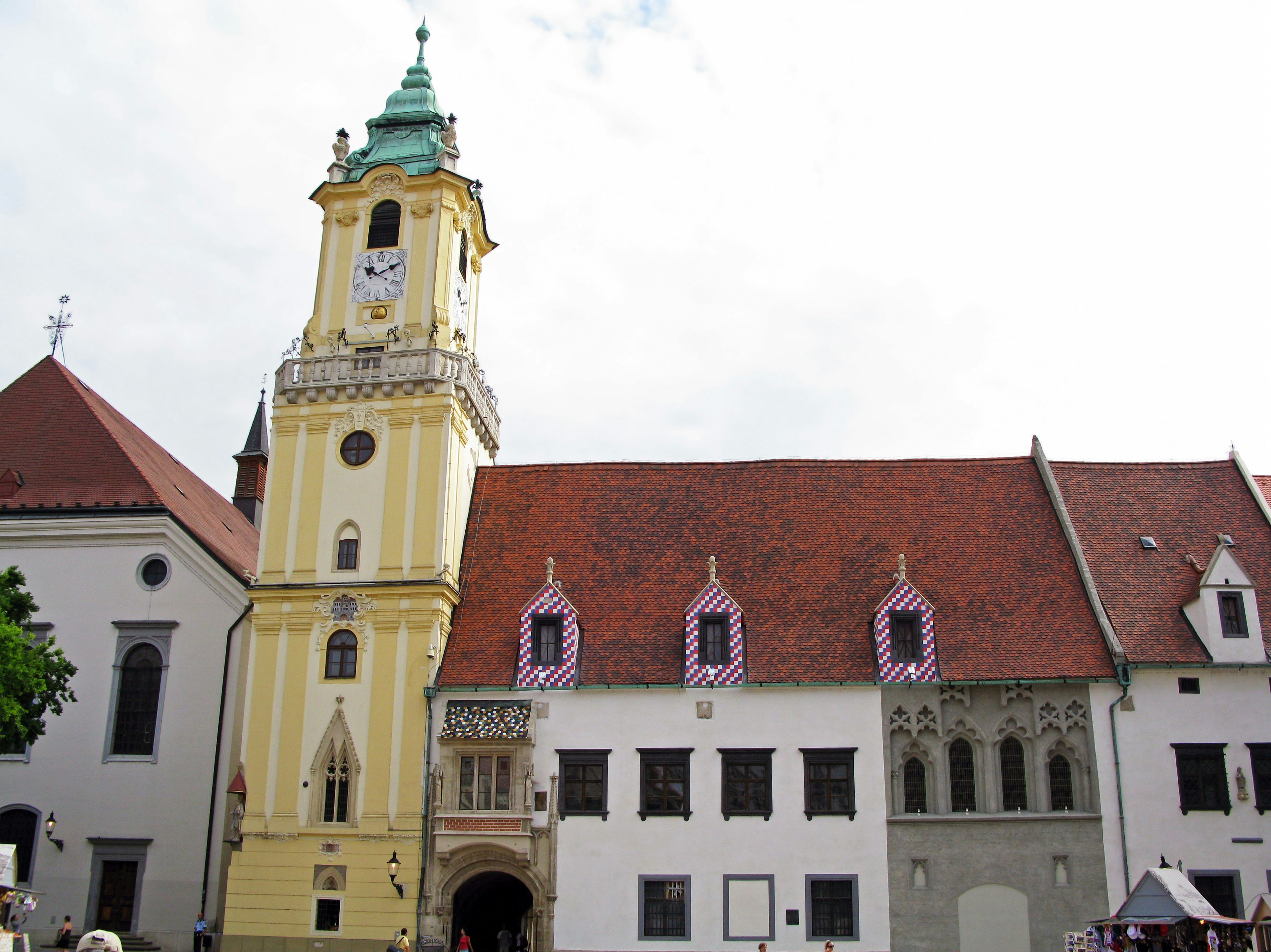 Historic building with a yellow clock tower and red roofs