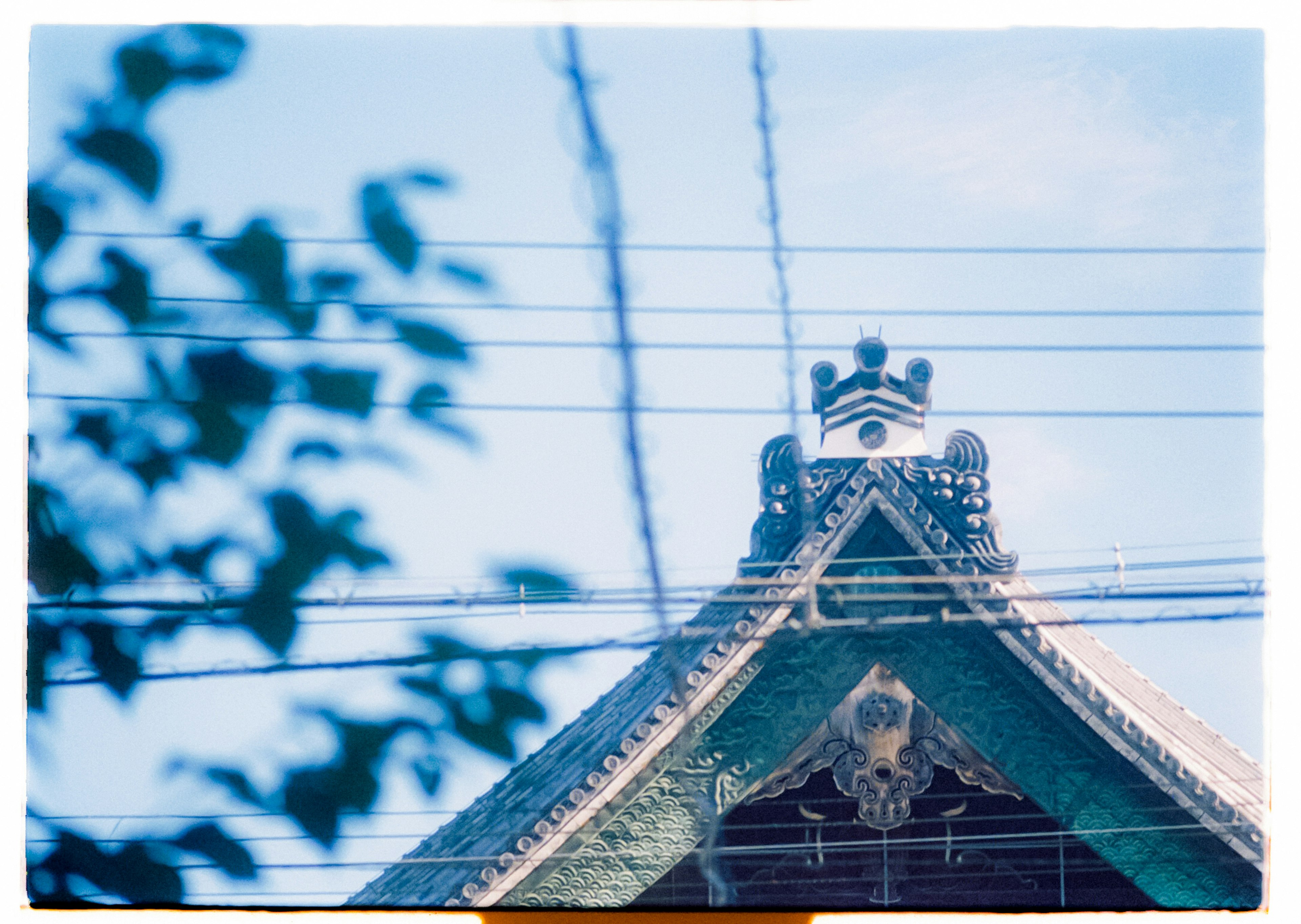 Decorative roof under blue sky with power lines