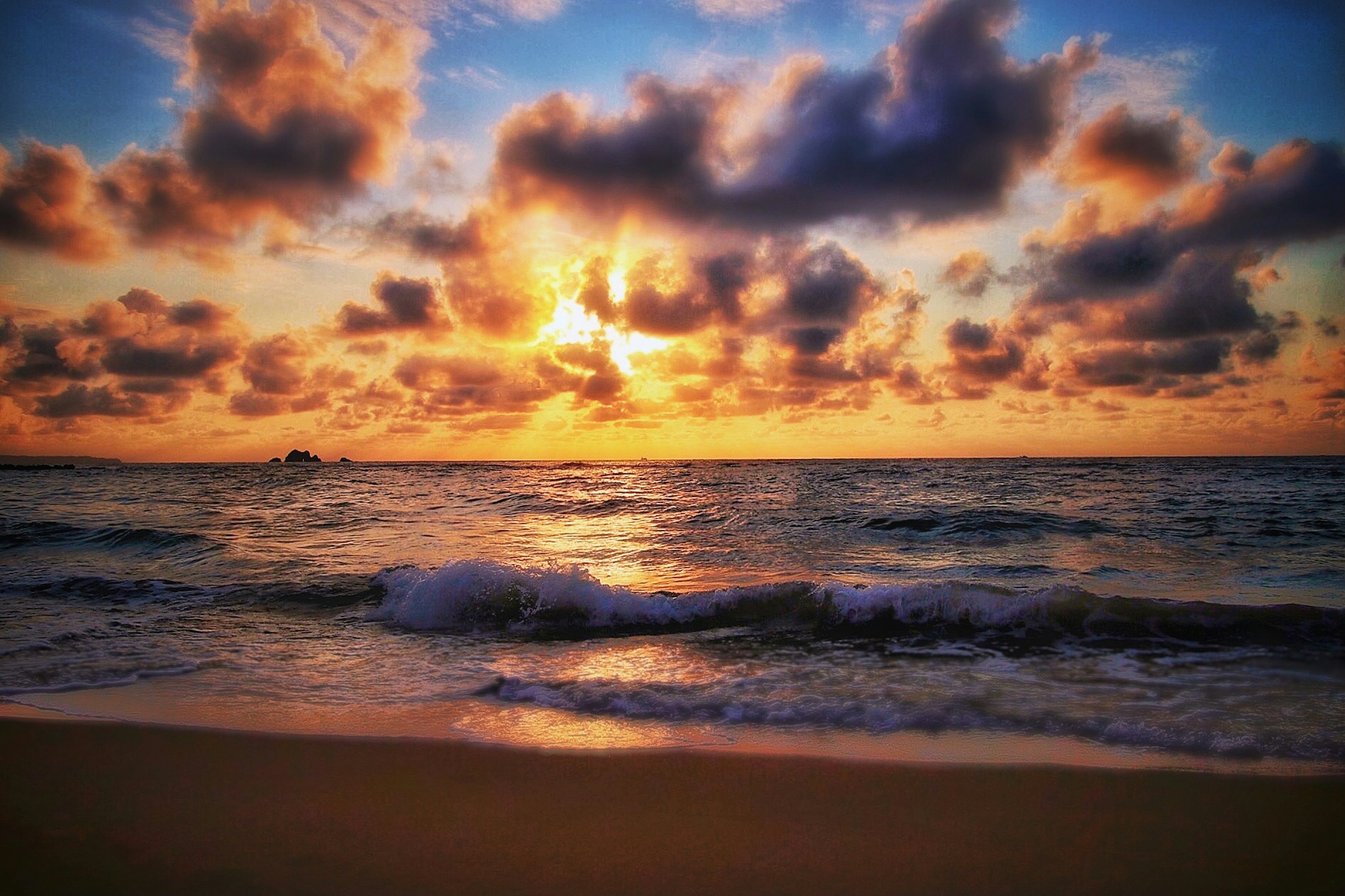 Pemandangan matahari terbenam yang menakjubkan di atas laut dengan langit oranye dan biru ombak lembut