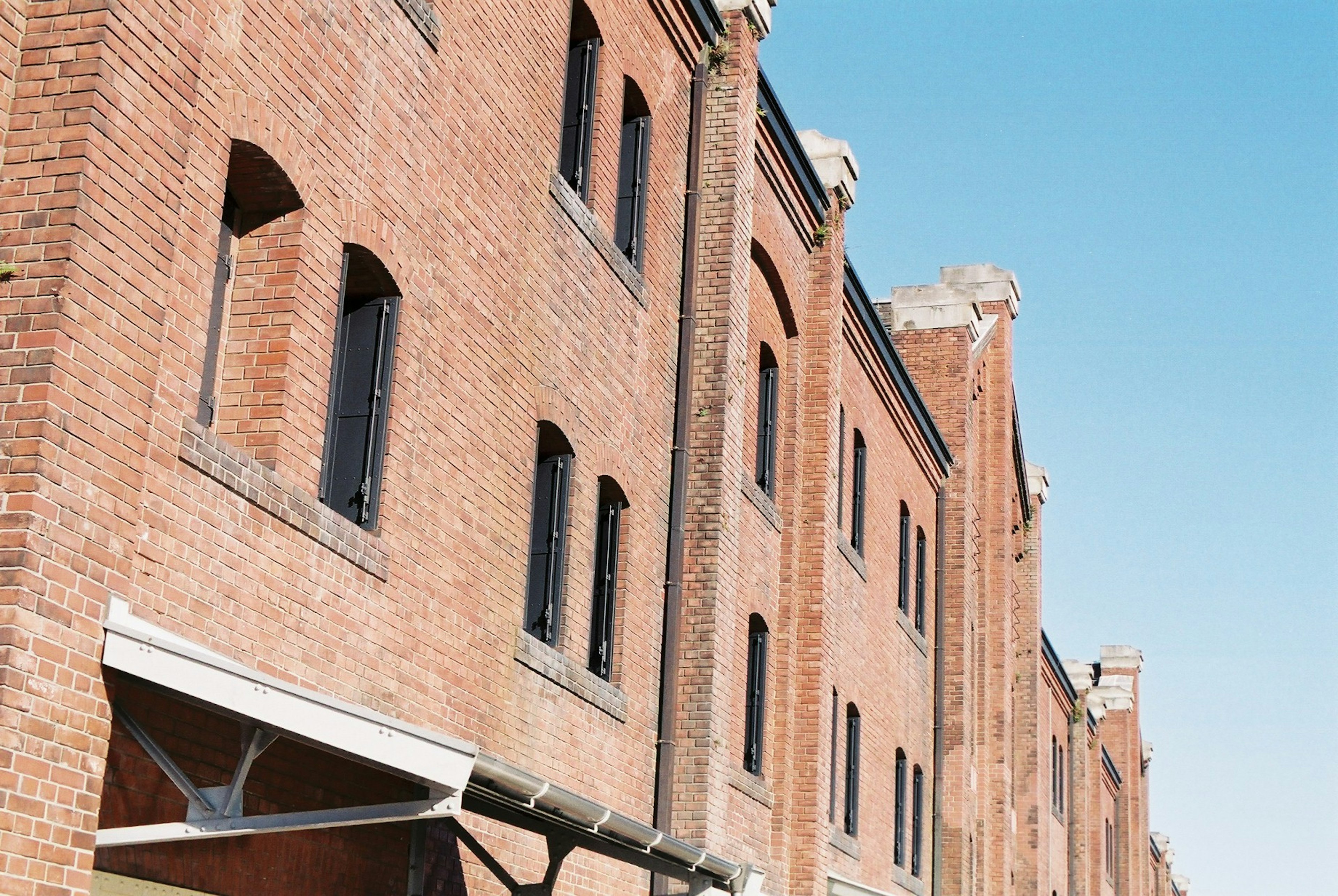 Row of brick buildings under a clear blue sky