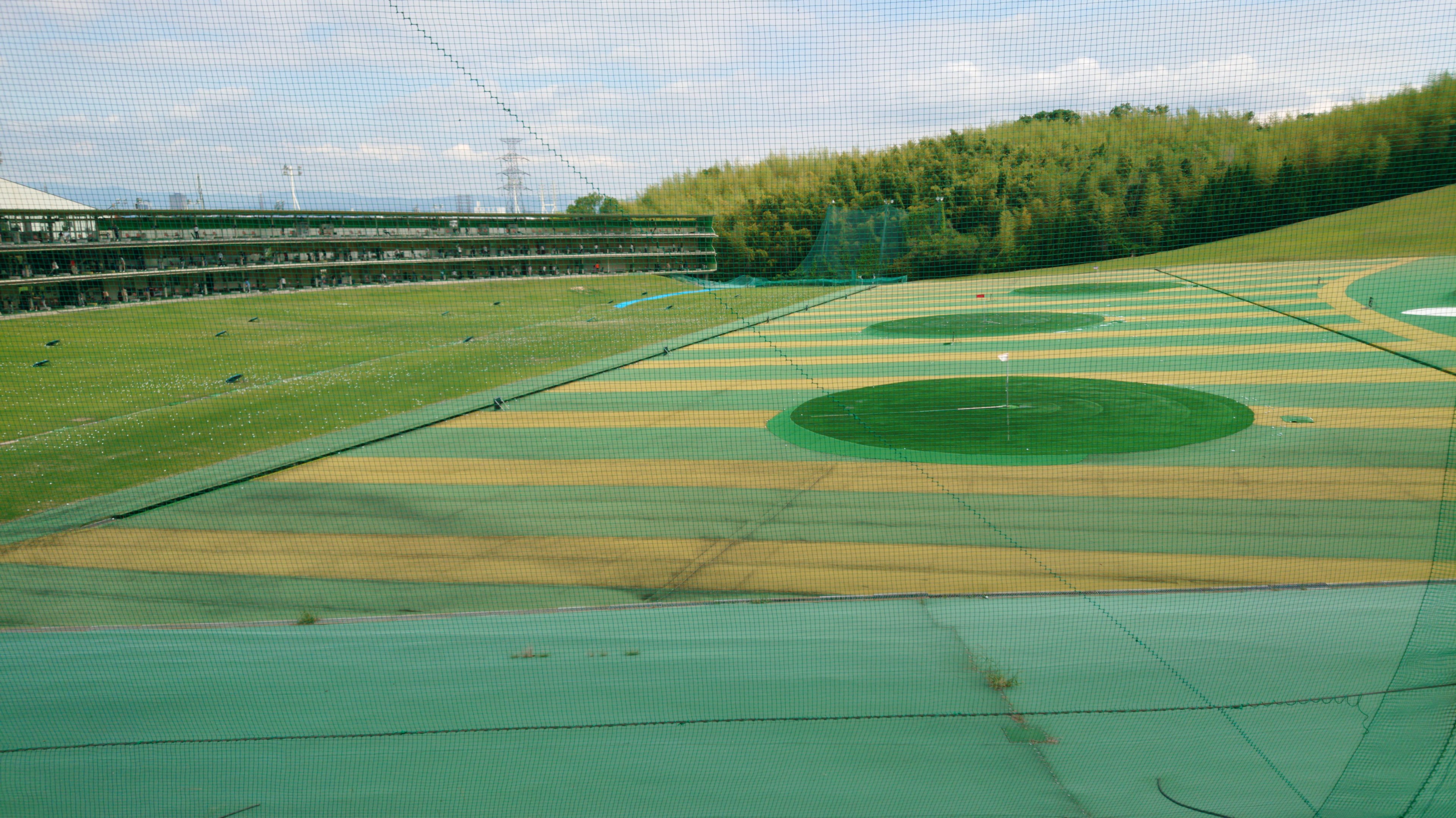 Campo de golf verde con área de práctica y objetivos