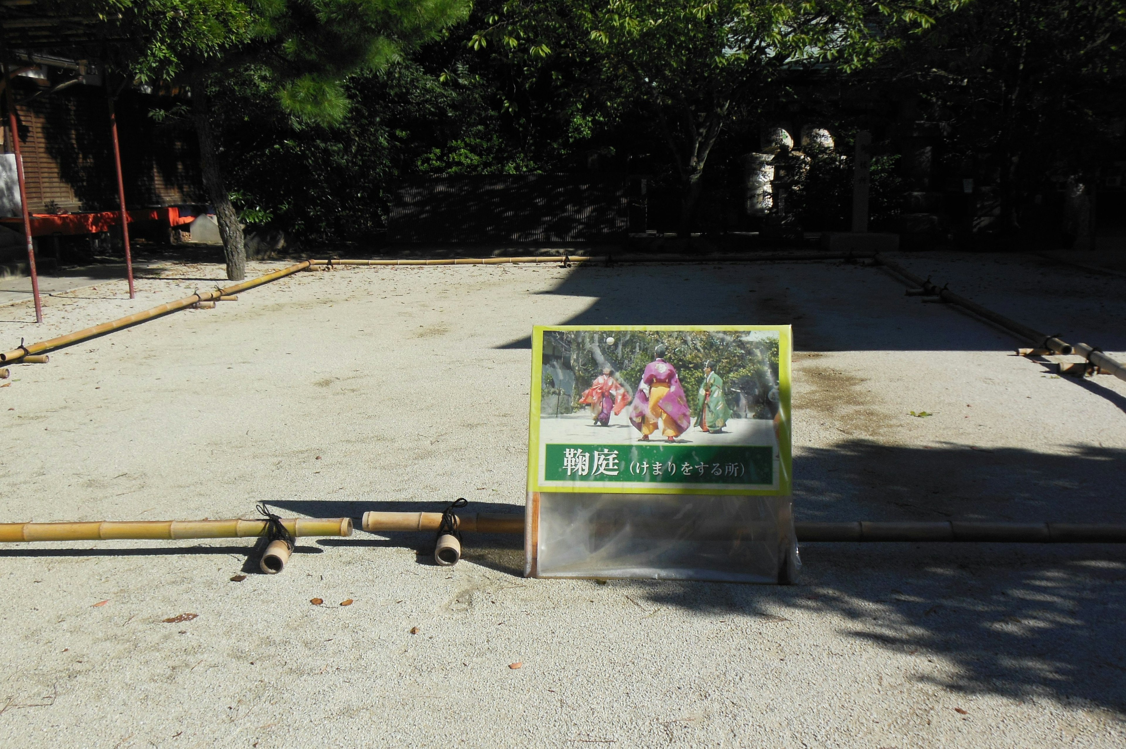 Sign for an outdoor play area on a gravel surface