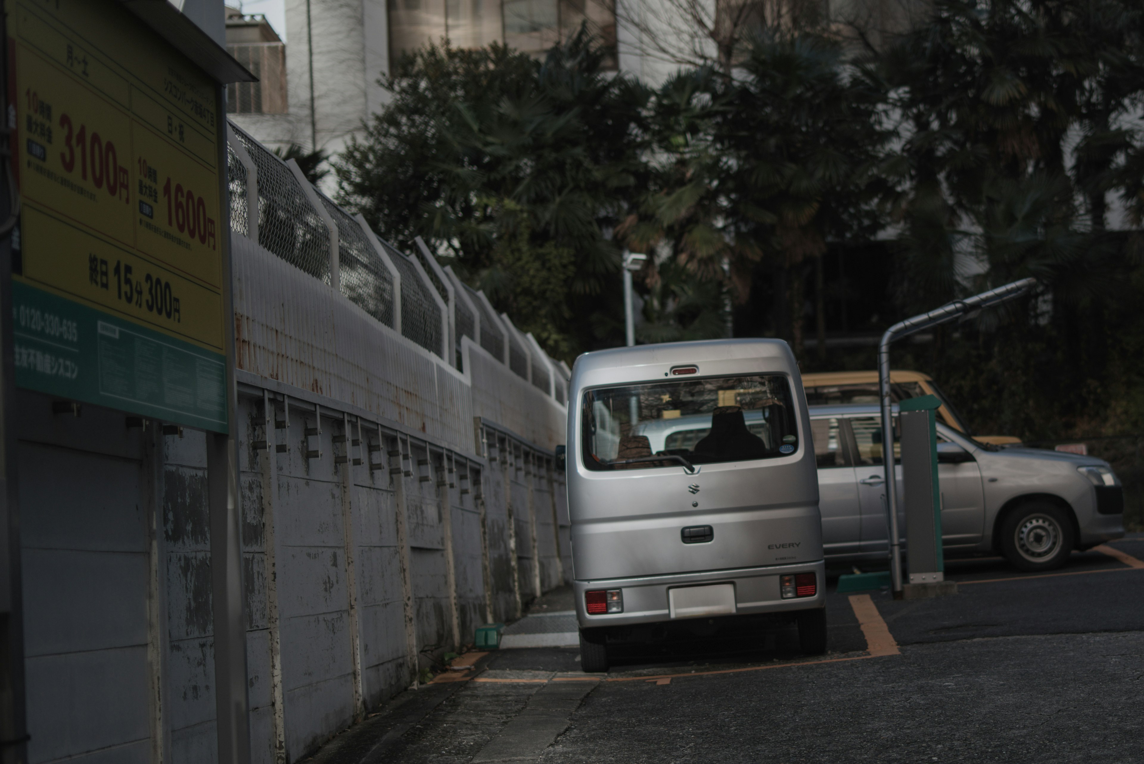 Silver van parked on a narrow street with surrounding vehicles