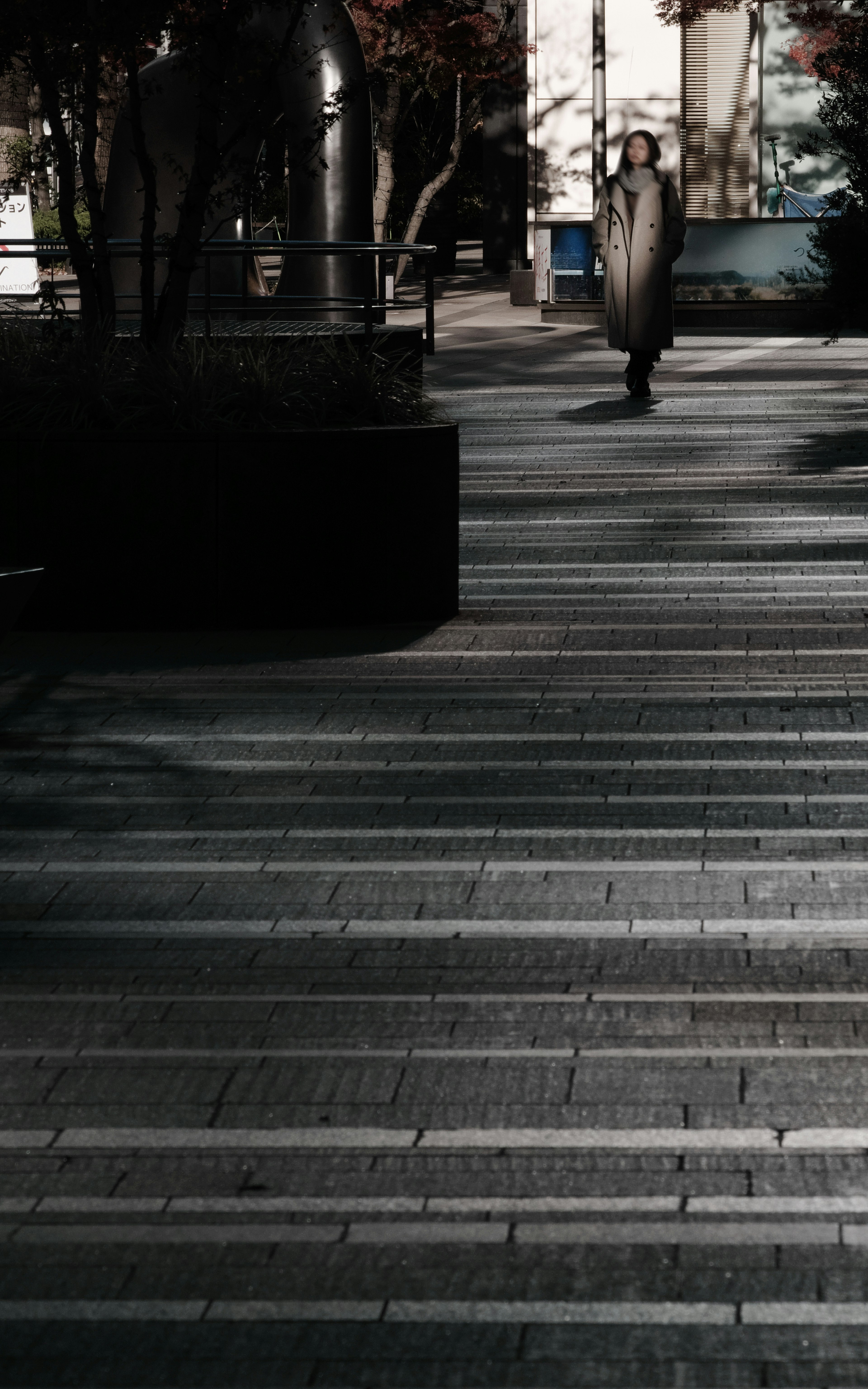 A person walking on a dimly lit street with striped pavement