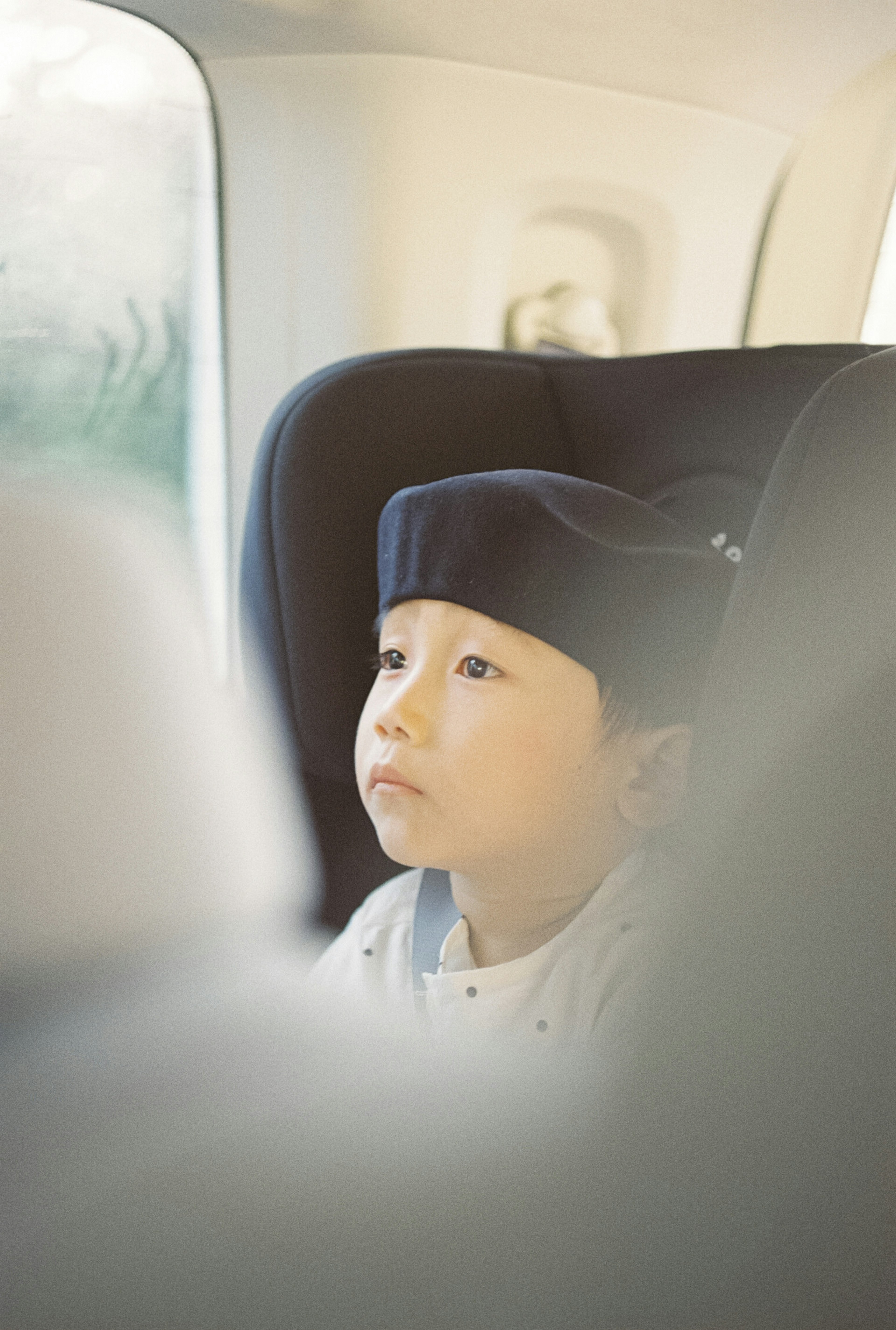 車の中で考え込む幼い男の子