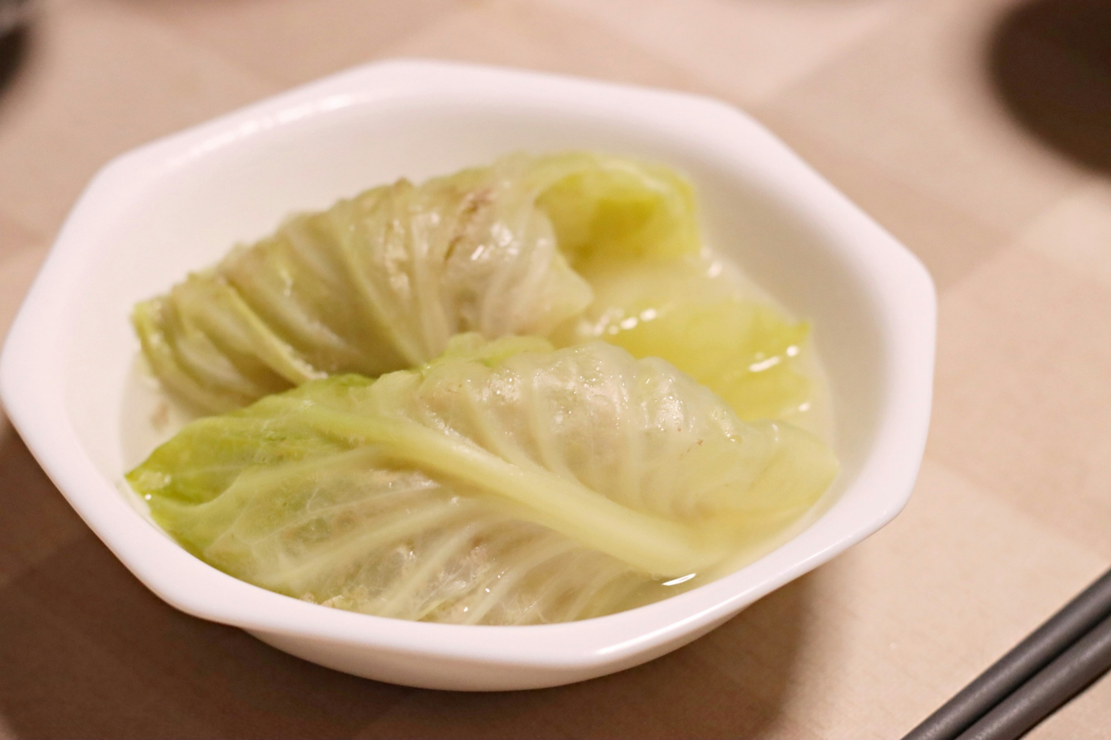 Two cabbage leaves arranged in a white dish