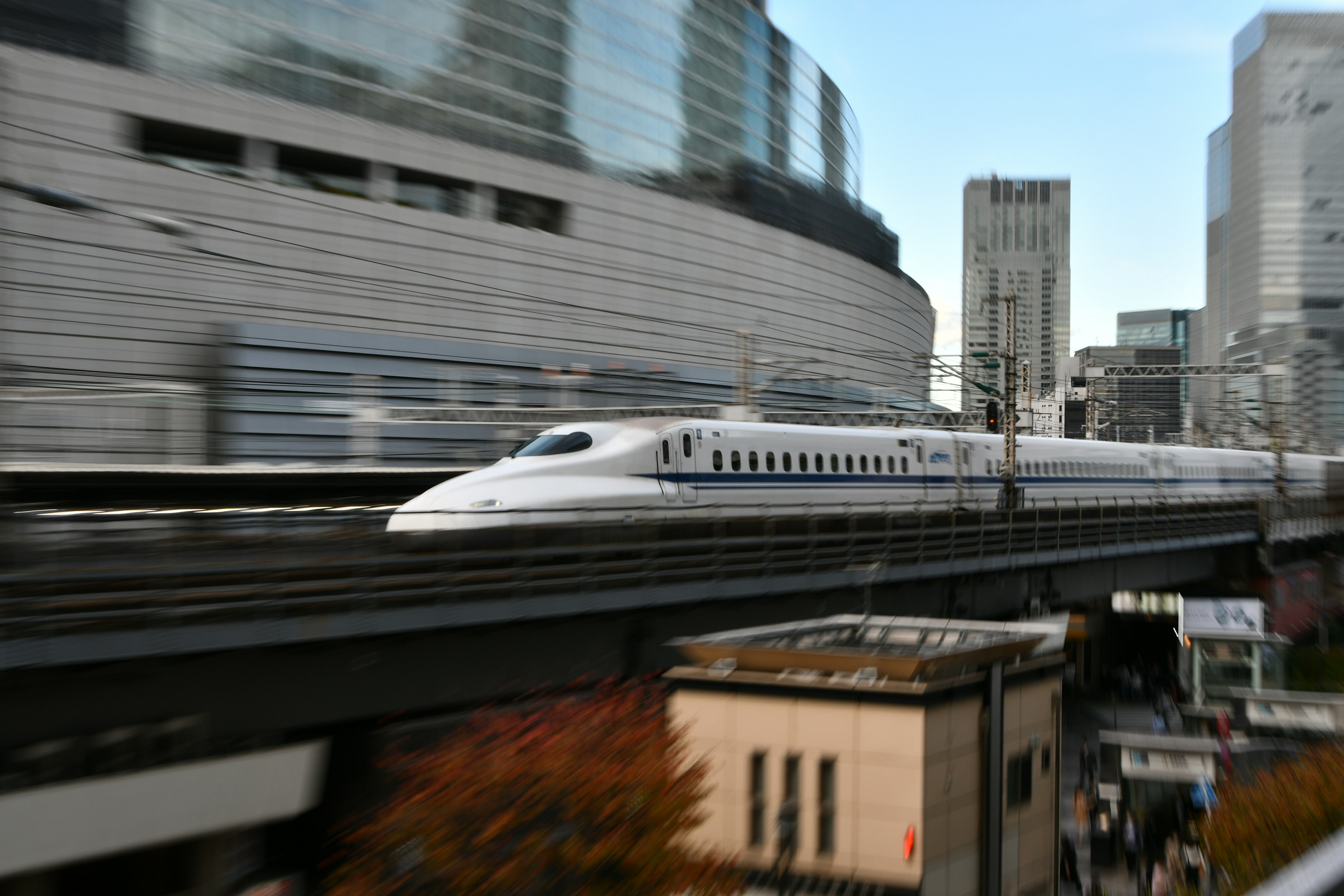 新幹線が都市の風景を背景に走行中のシーン