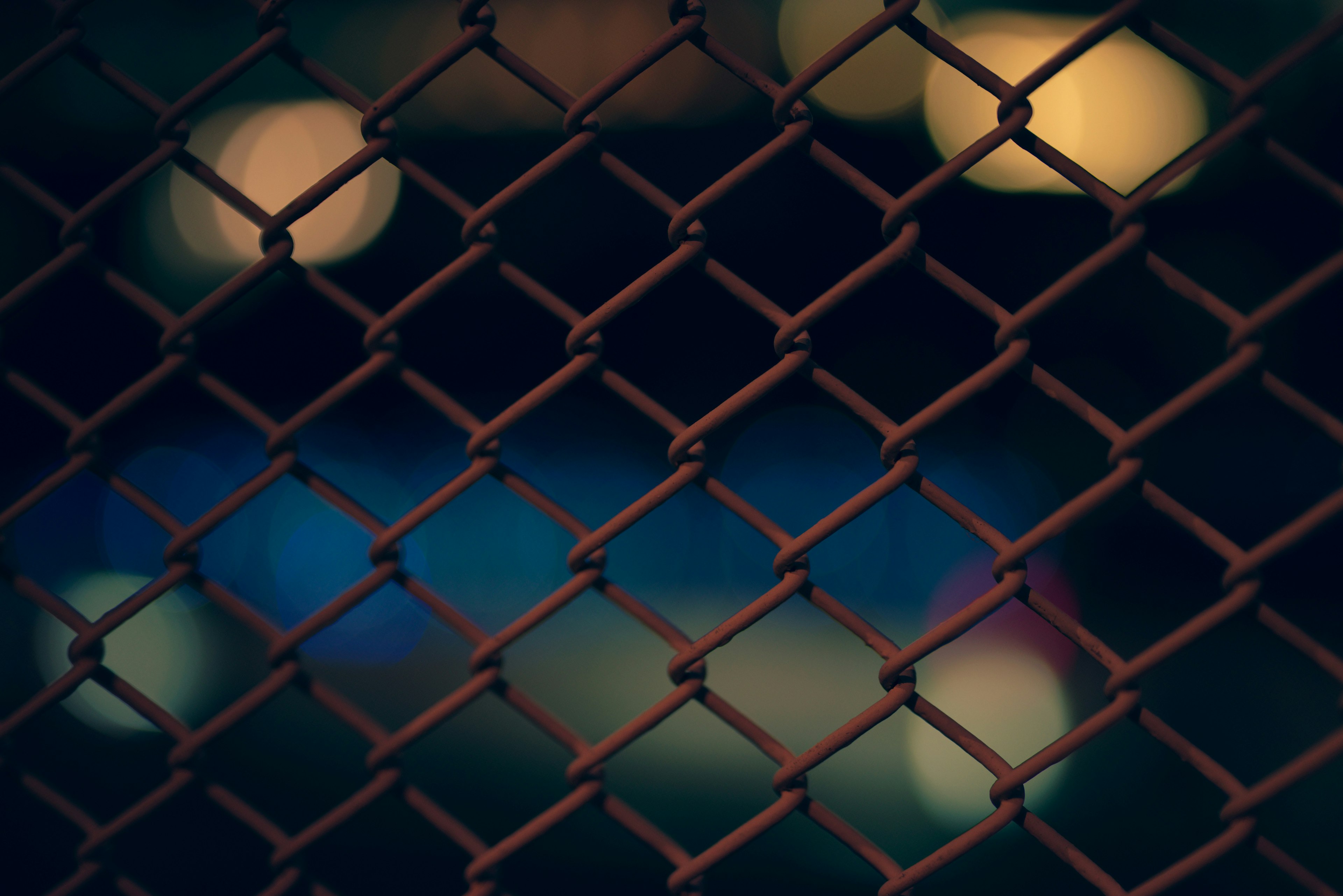 Close-up of a chain link fence with a blurred background