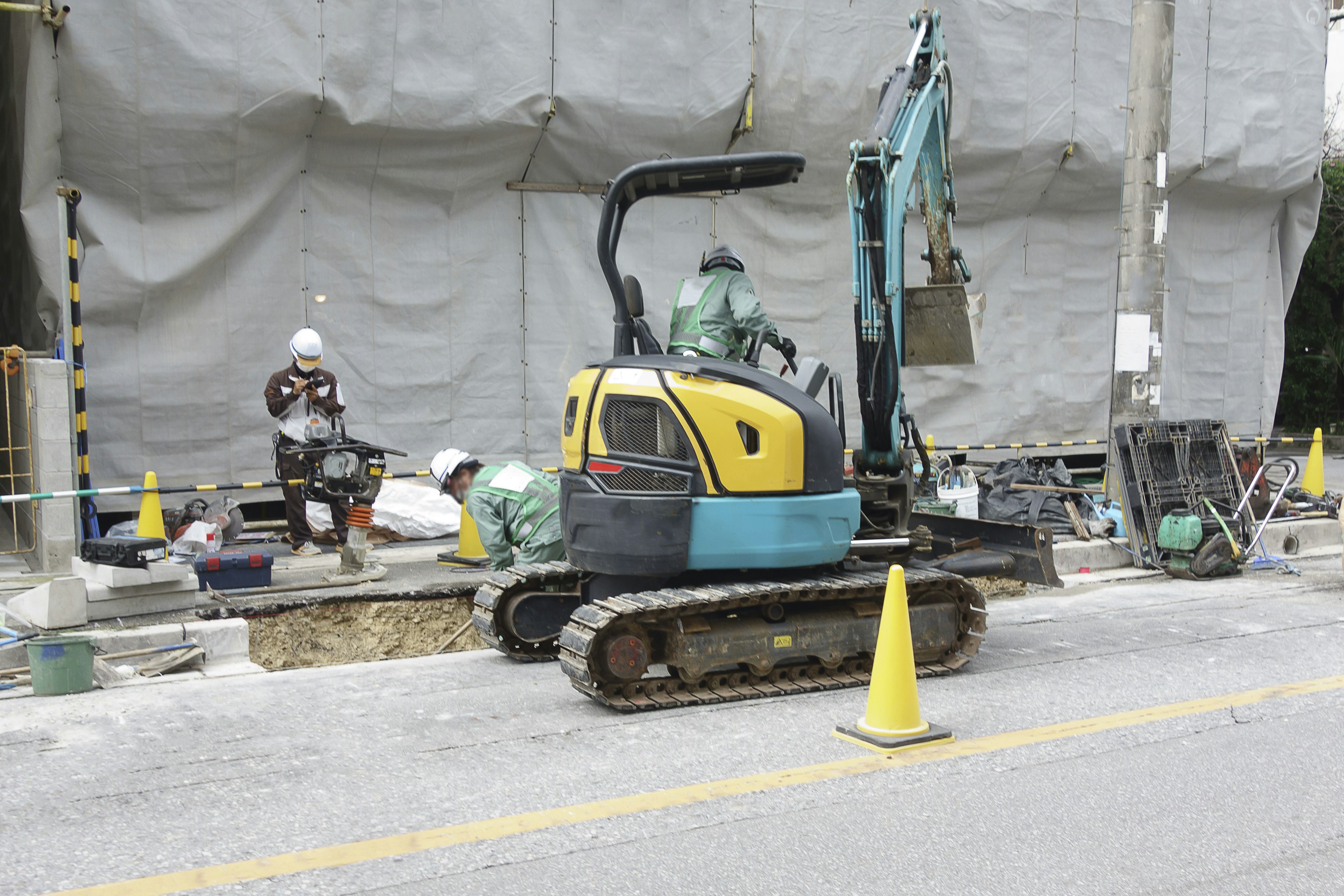 Chantier de construction avec une petite excavatrice et des travailleurs