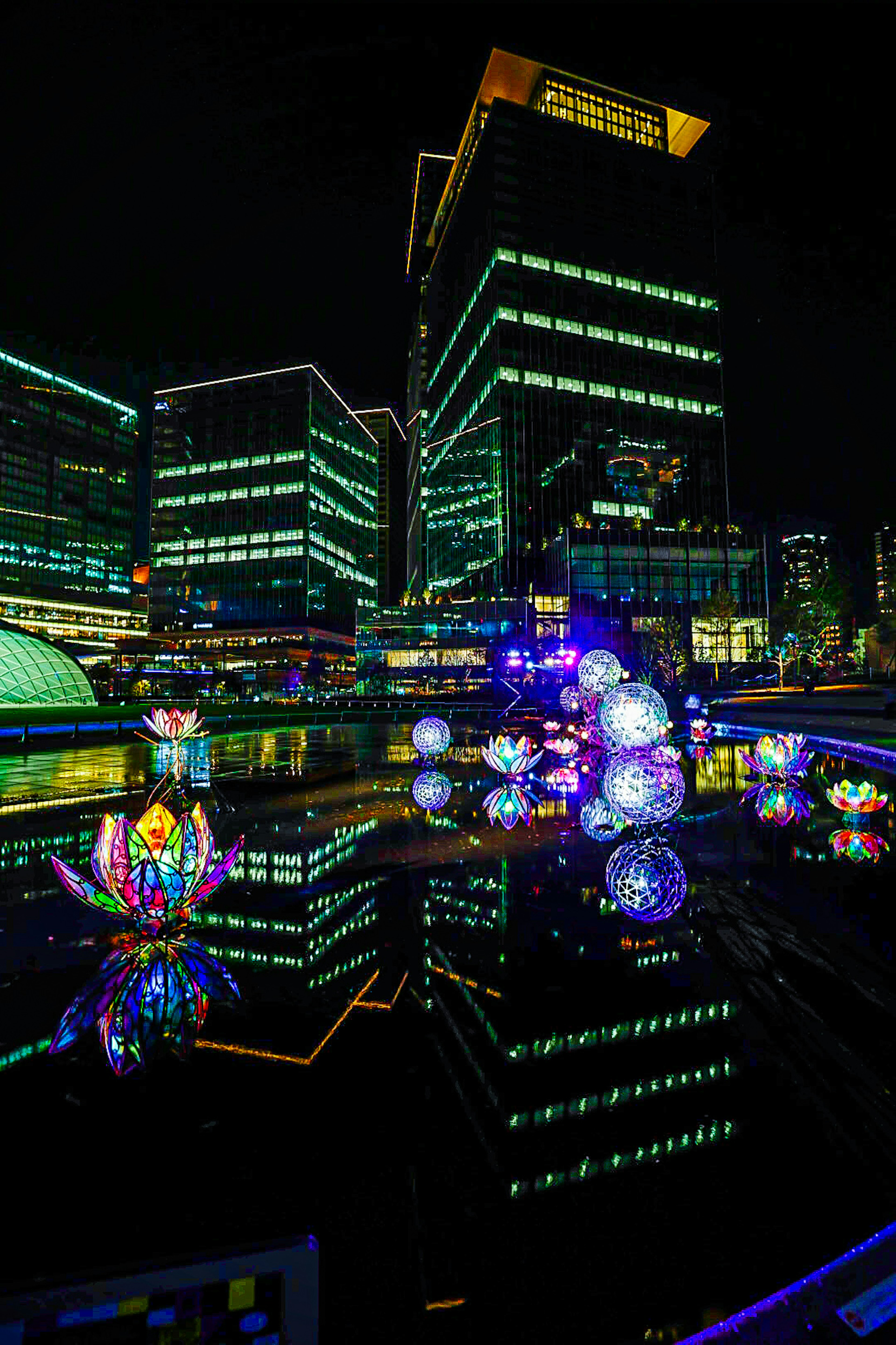 Bunte beleuchtete Objekte, die sich nachts in einer Stadtlandschaft spiegeln