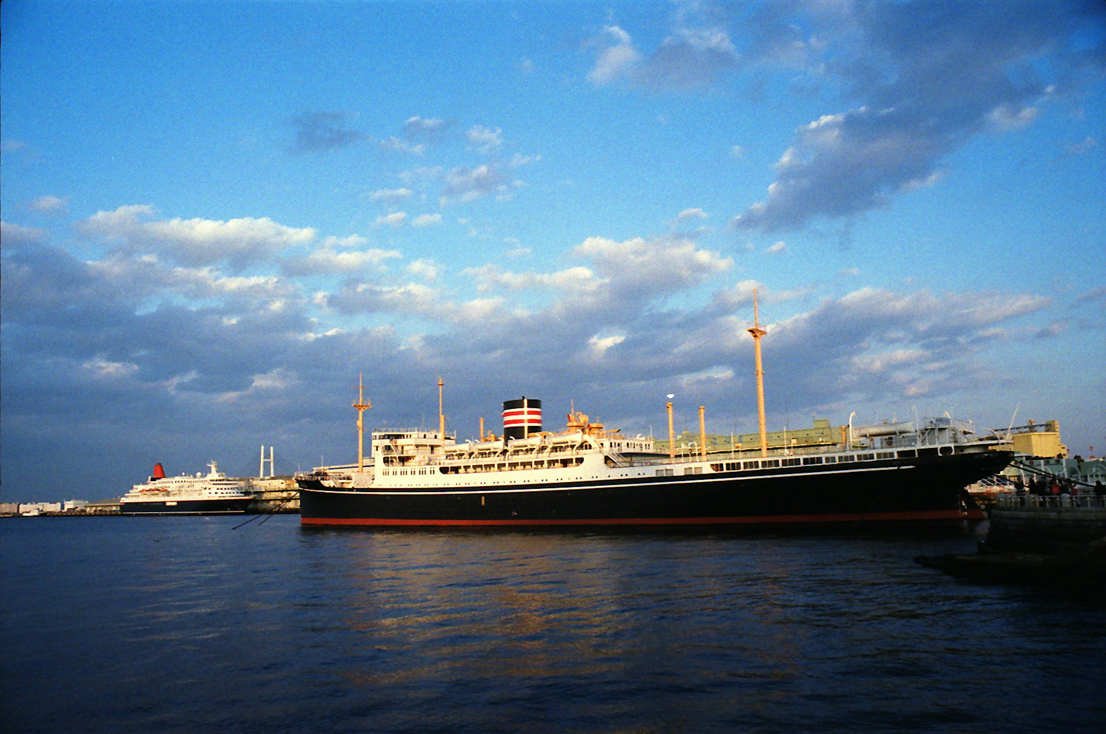 Grand bateau de passagers amarré au port sous un ciel bleu