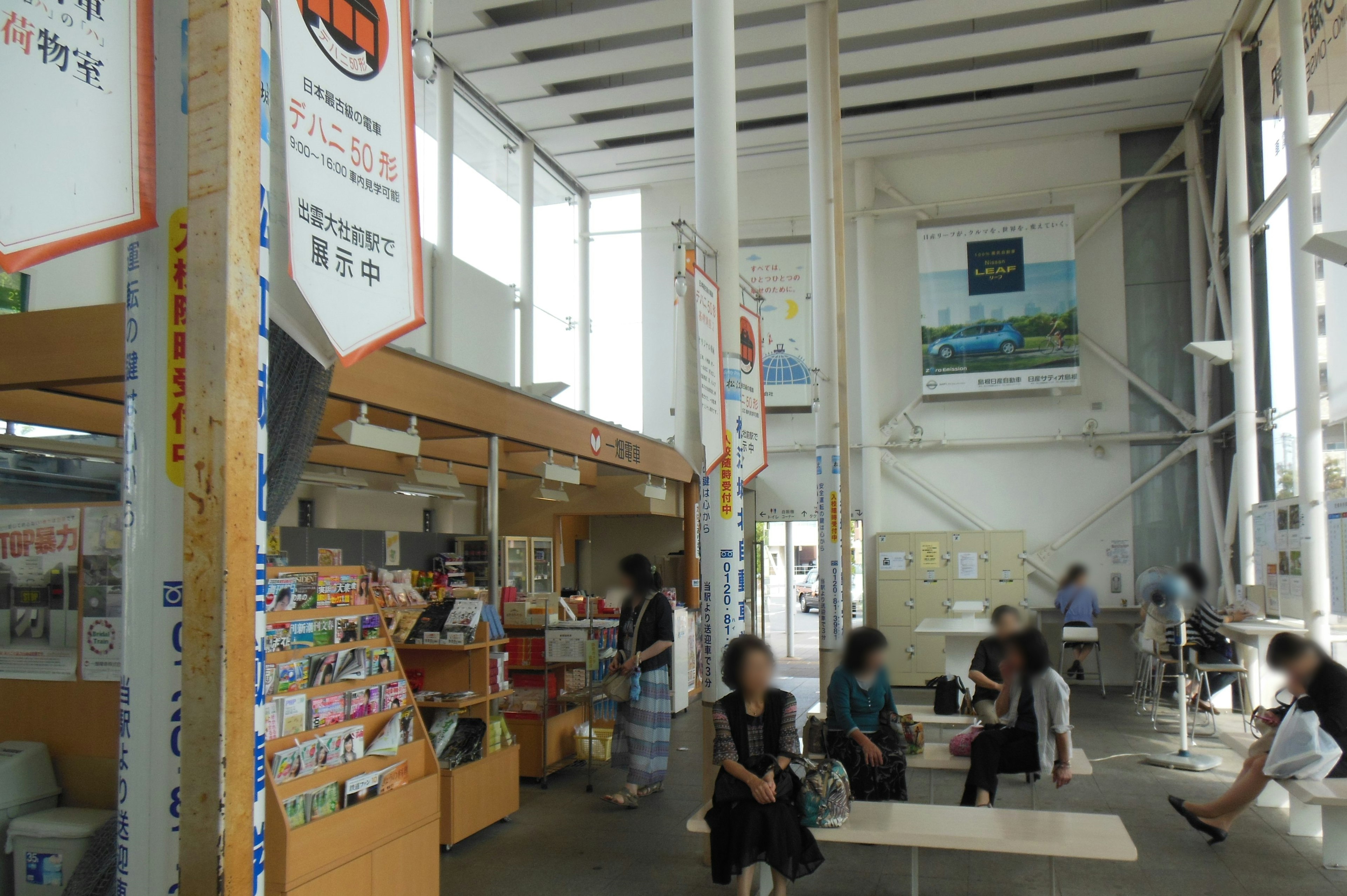 Bright public space with people seated large windows allowing natural light