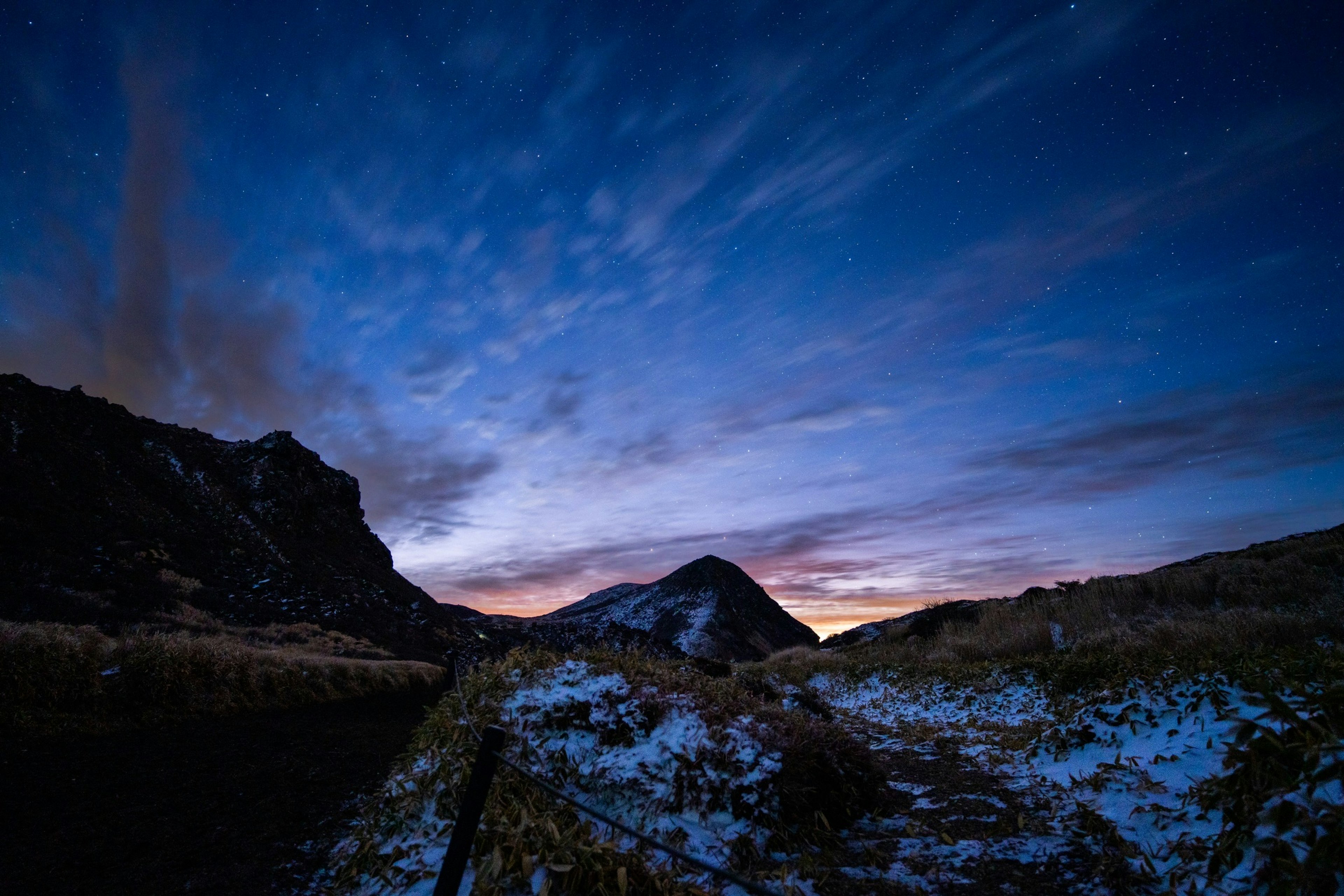 Montagnes enneigées sous un ciel bleu au crépuscule