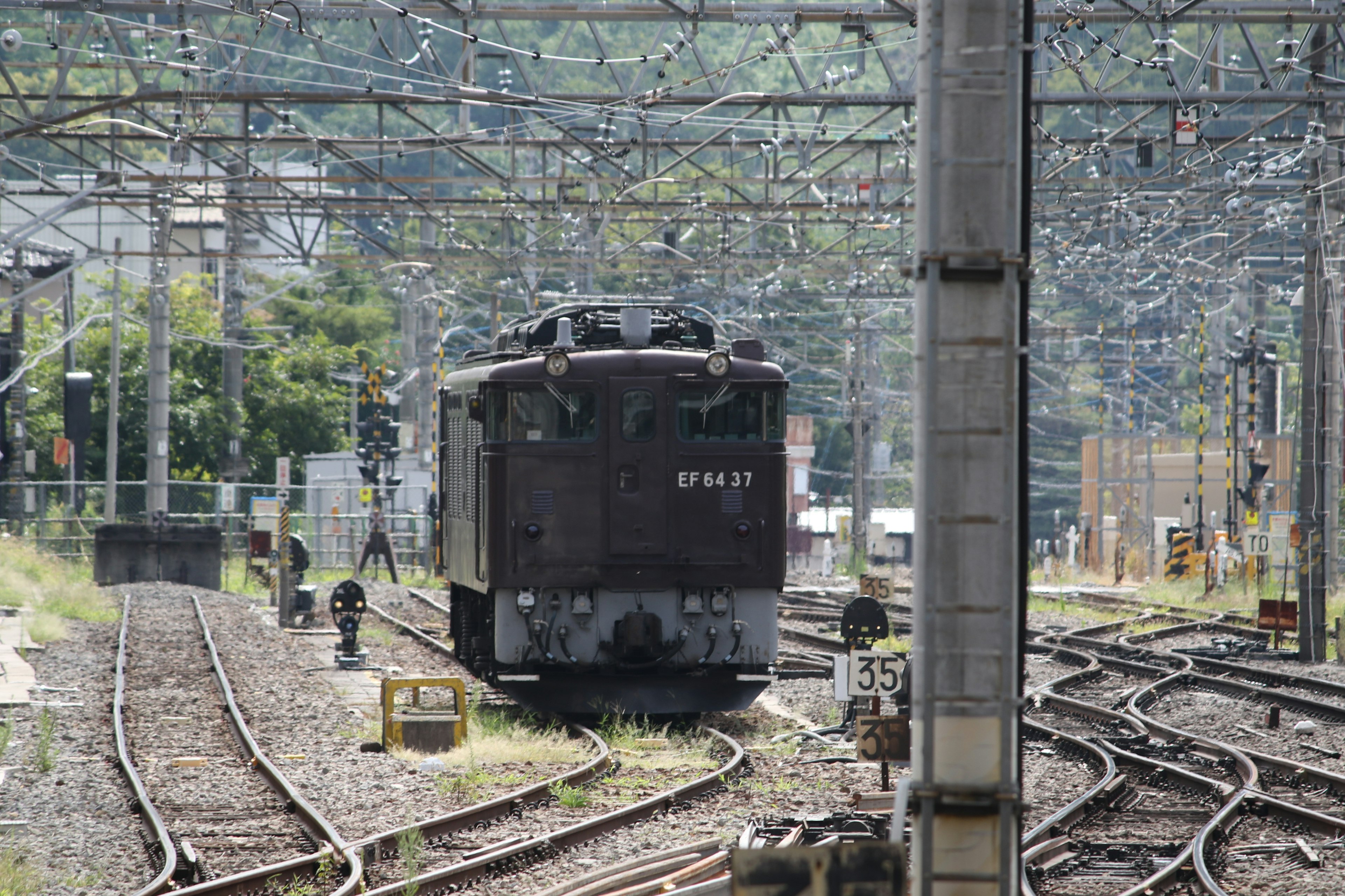 鉄道の車両が線路に停車している風景周辺には鉄道の架線が見える