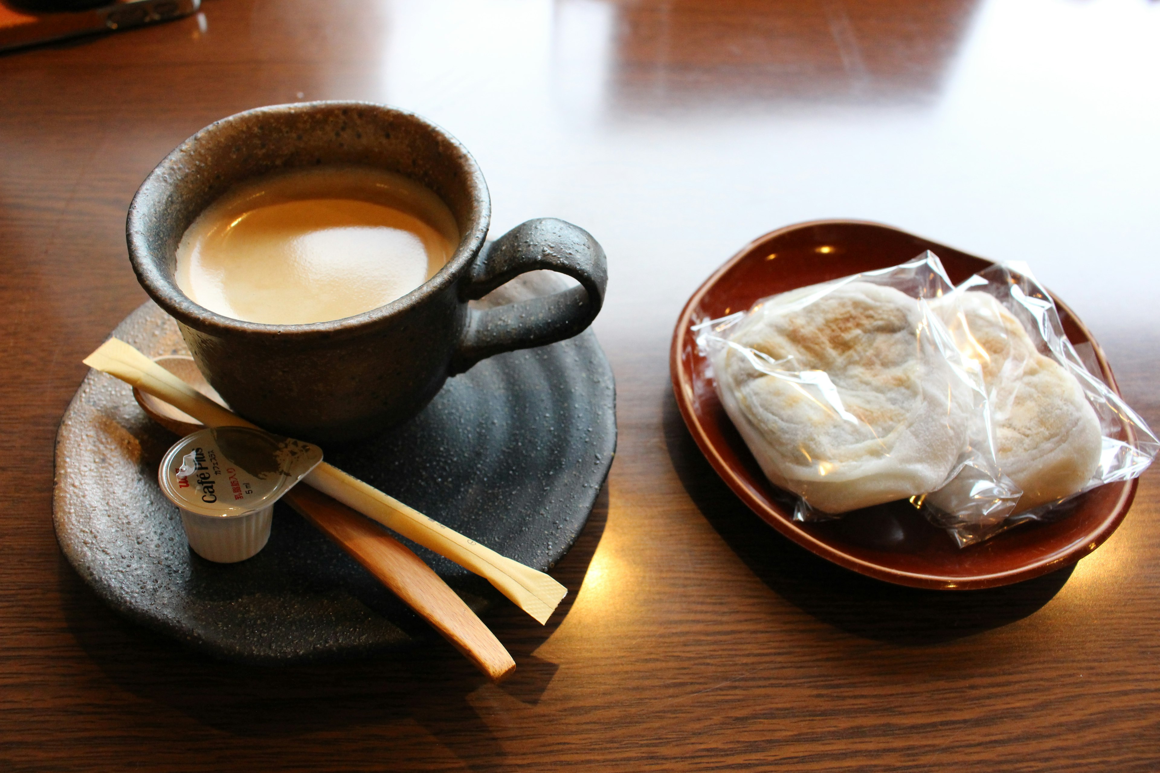 Eine Tasse Kaffee und japanische Süßigkeiten auf einem Holztisch