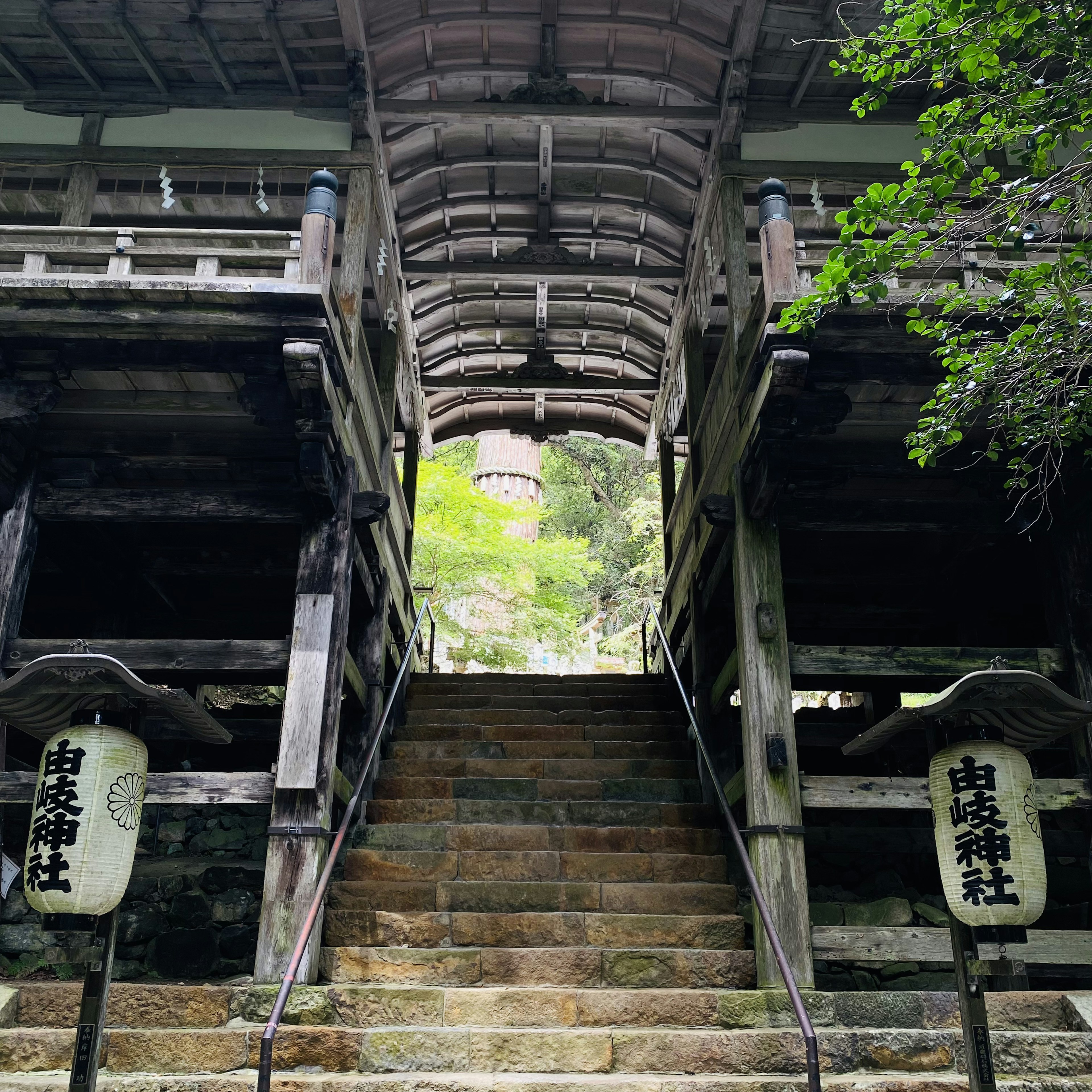 古い神社の階段と木造の構造物が見える風景