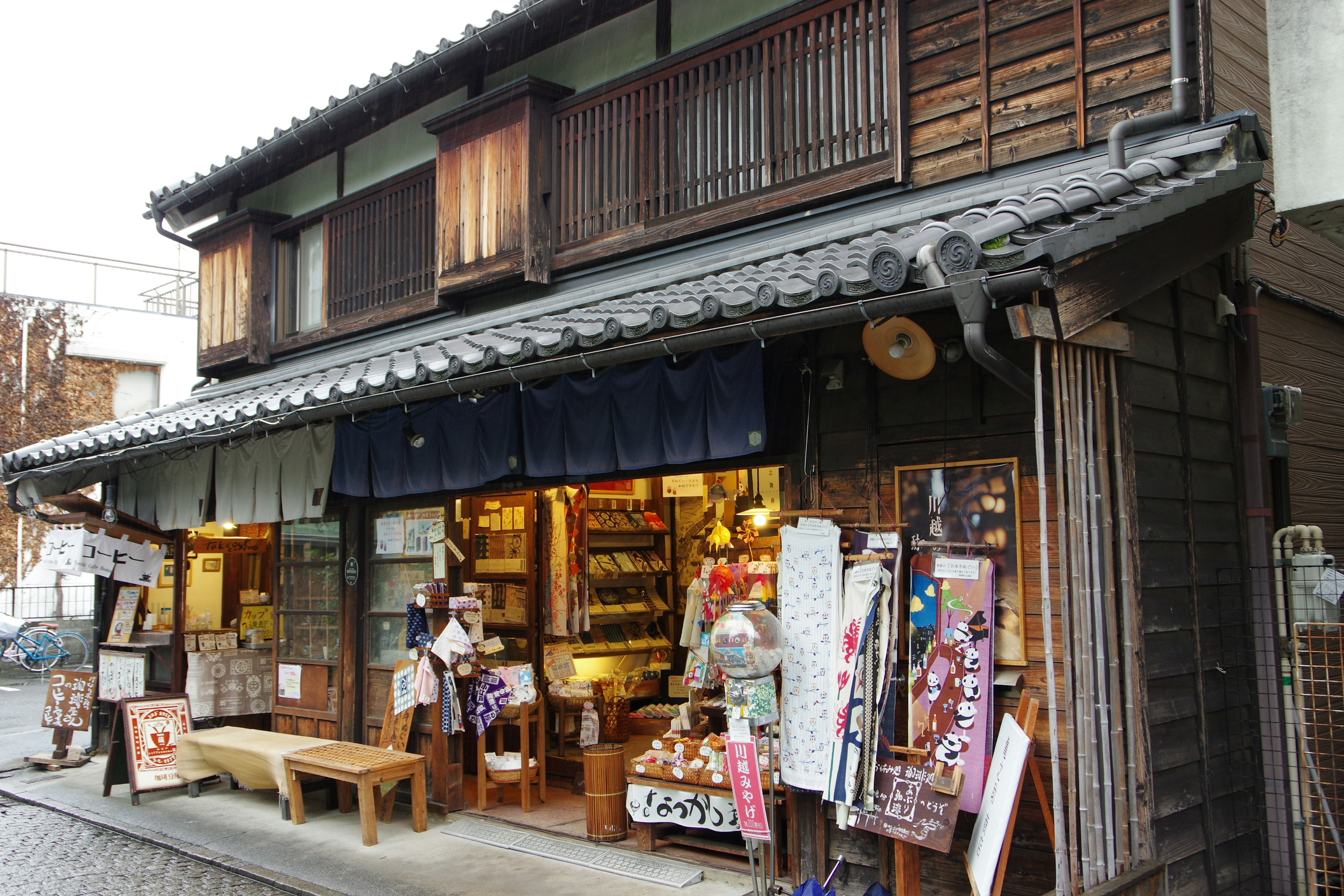 ด้านนอกของร้านค้าญี่ปุ่นแบบดั้งเดิมที่มีหน้าต่างไม้และโนเรน