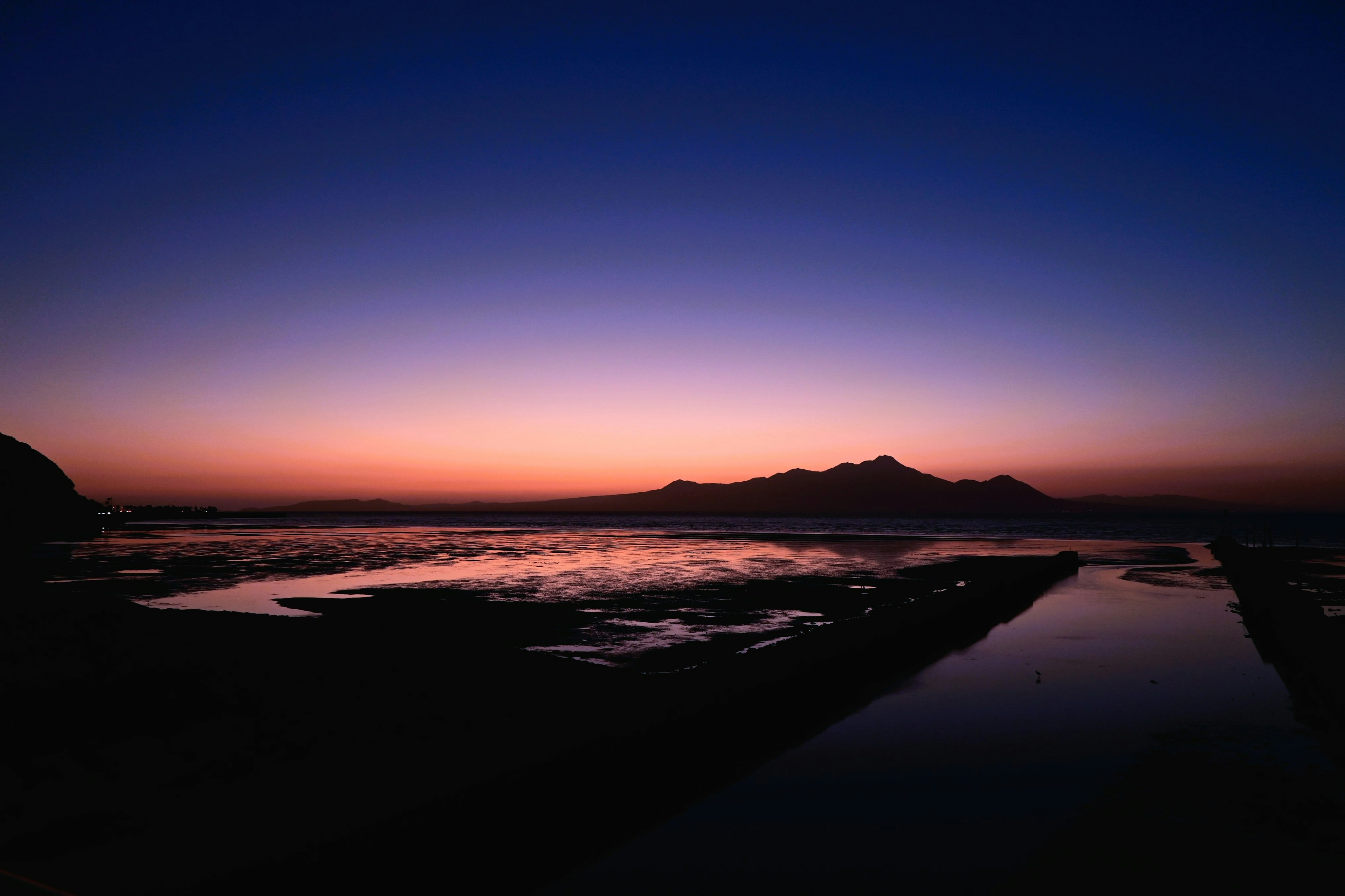 夕暮れ時の海と山の美しい風景