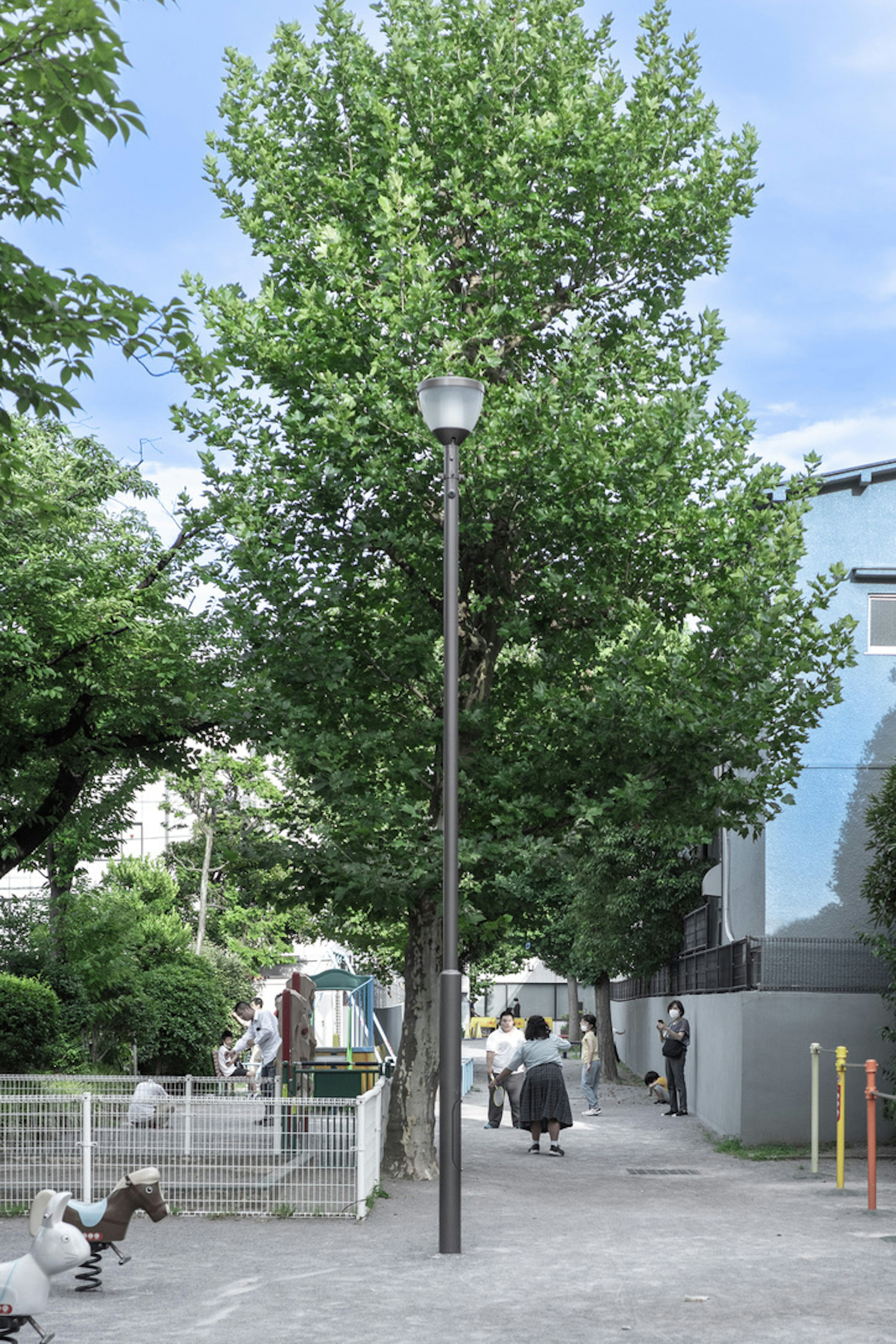 歩道に立つ街灯と周囲の緑の木々