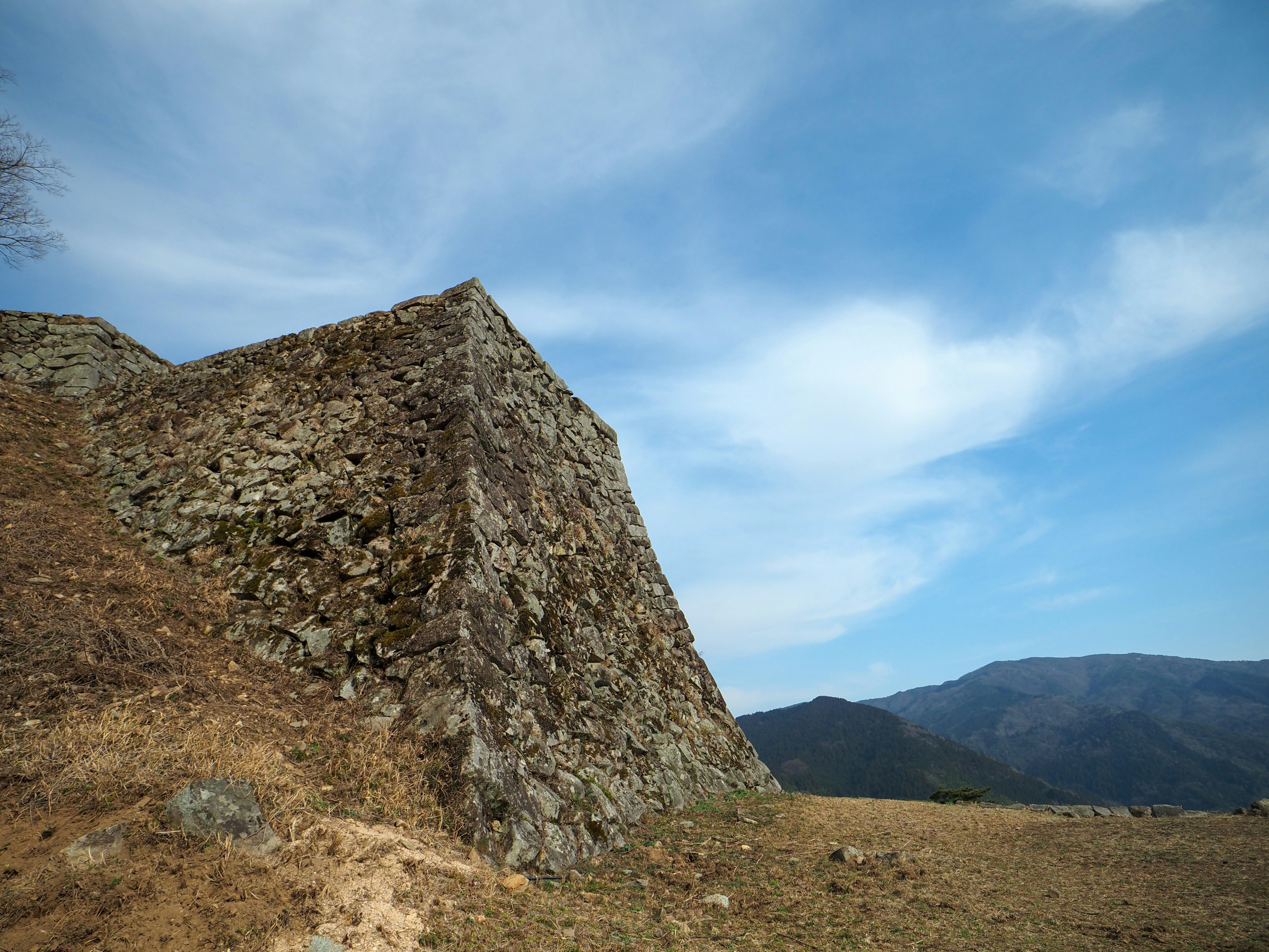 Sección de muro de castillo de piedra bajo un cielo azul