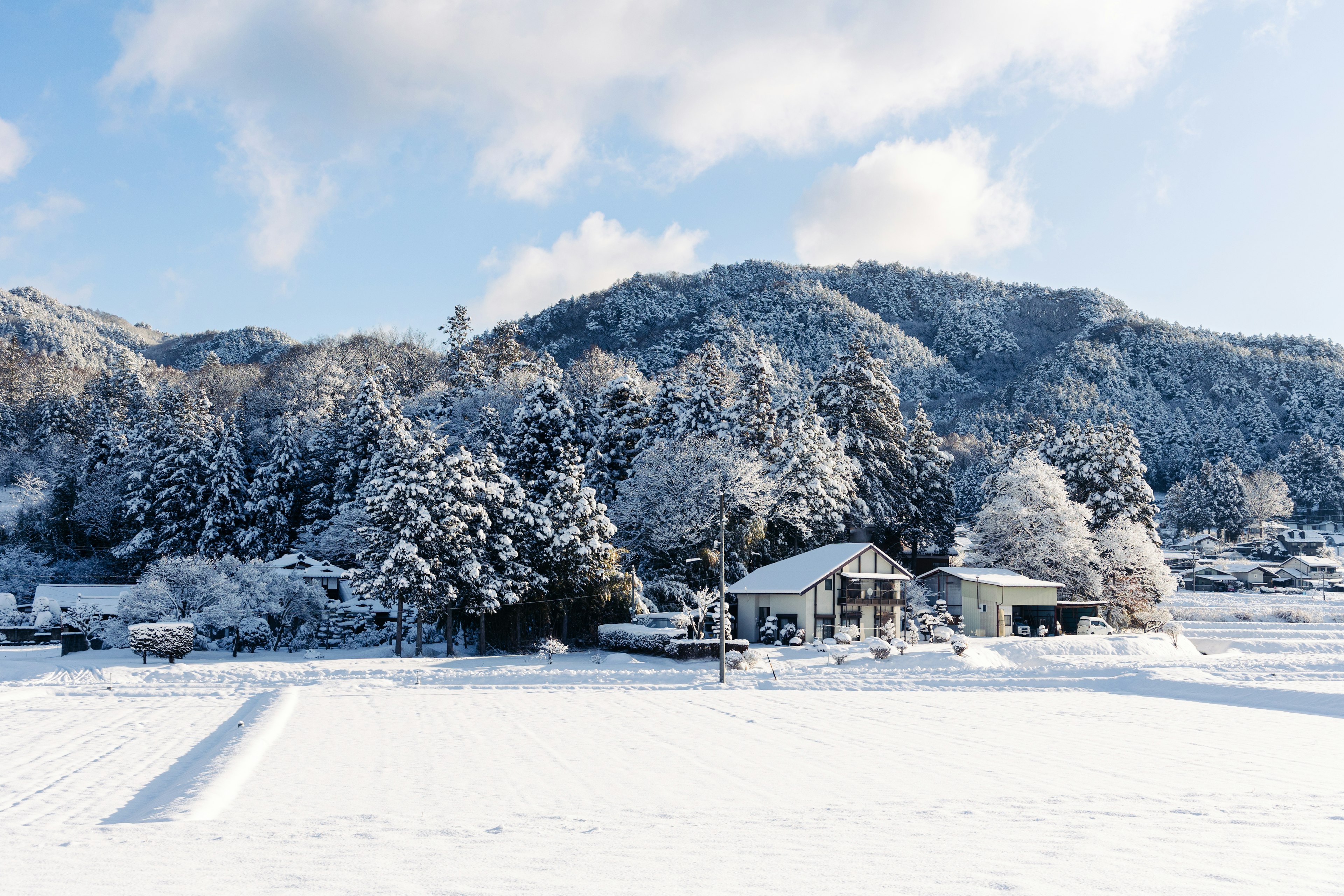 Snow-covered mountains and a house in a winter landscape