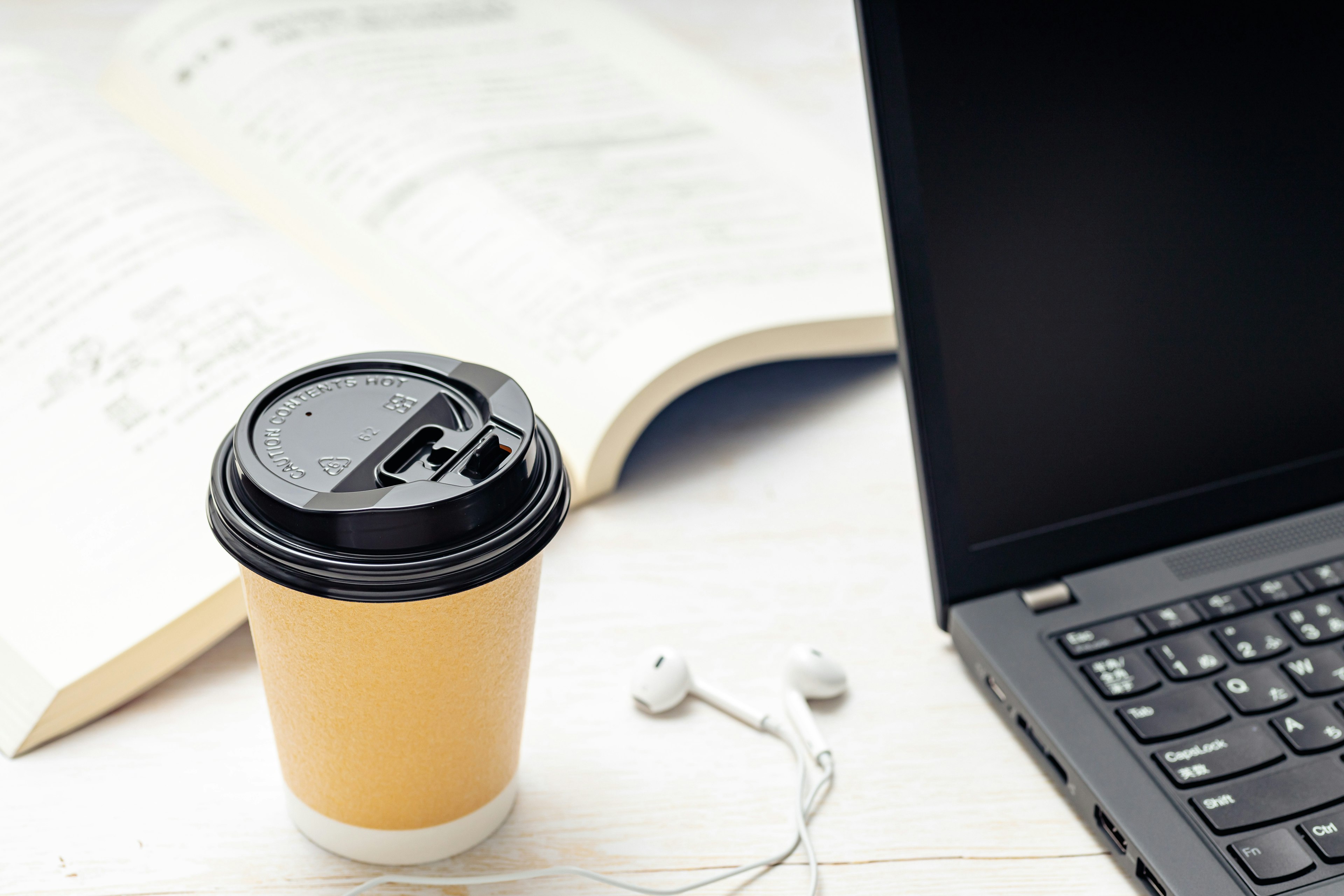 Workspace featuring a coffee cup and laptop