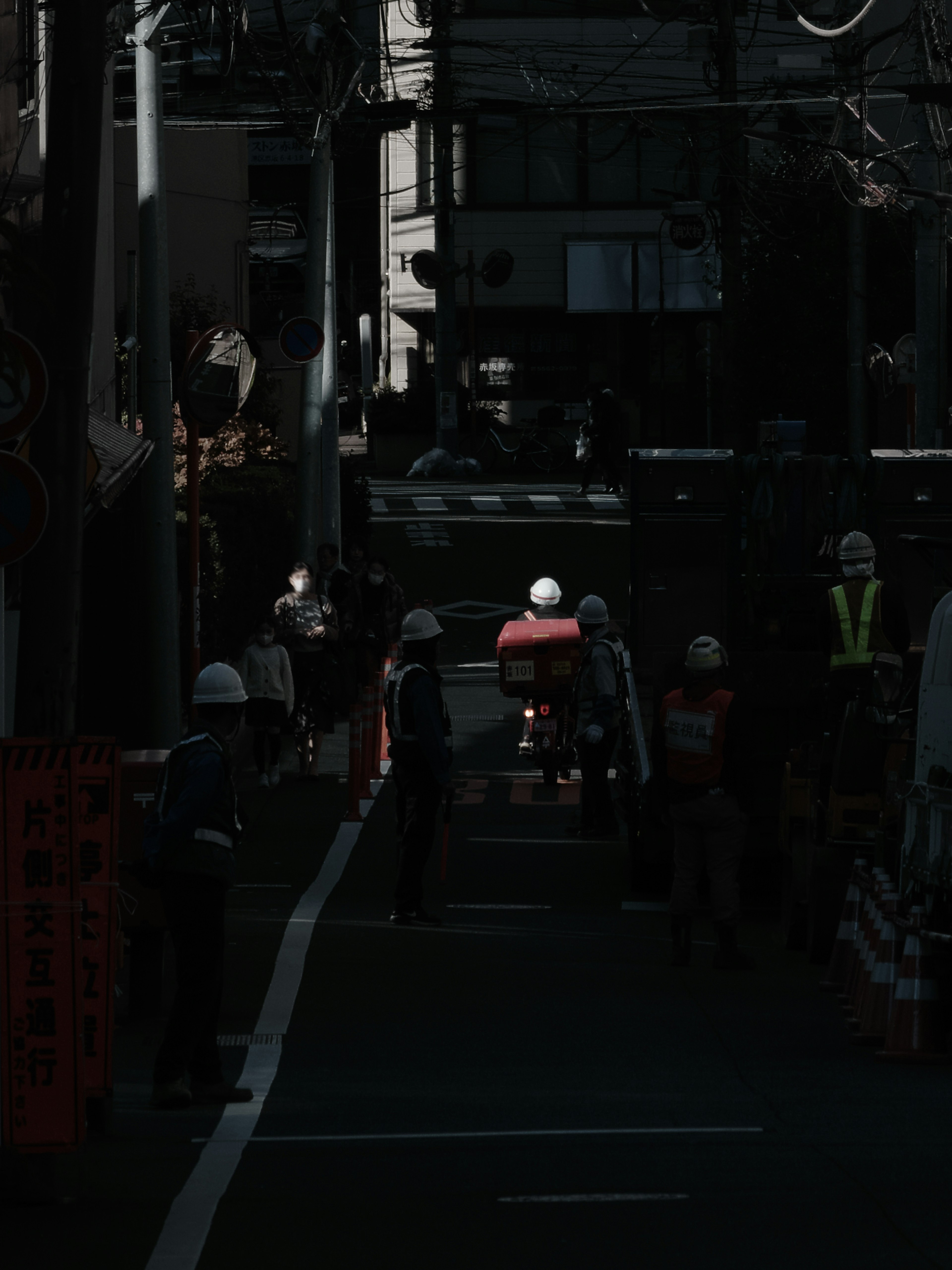 Workers and a motorcycle on a dimly lit street