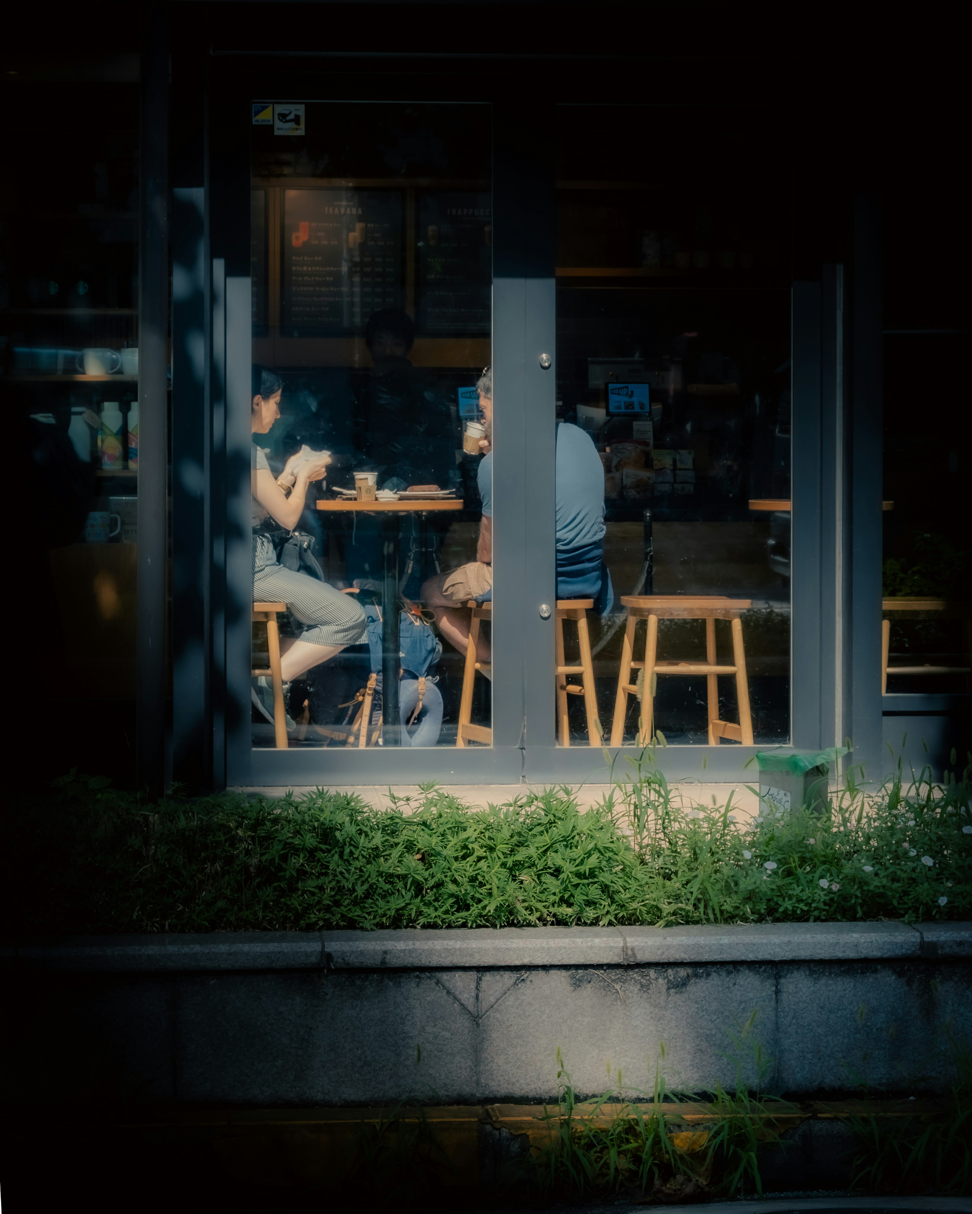 Group of people sitting in a cafe visible through the window