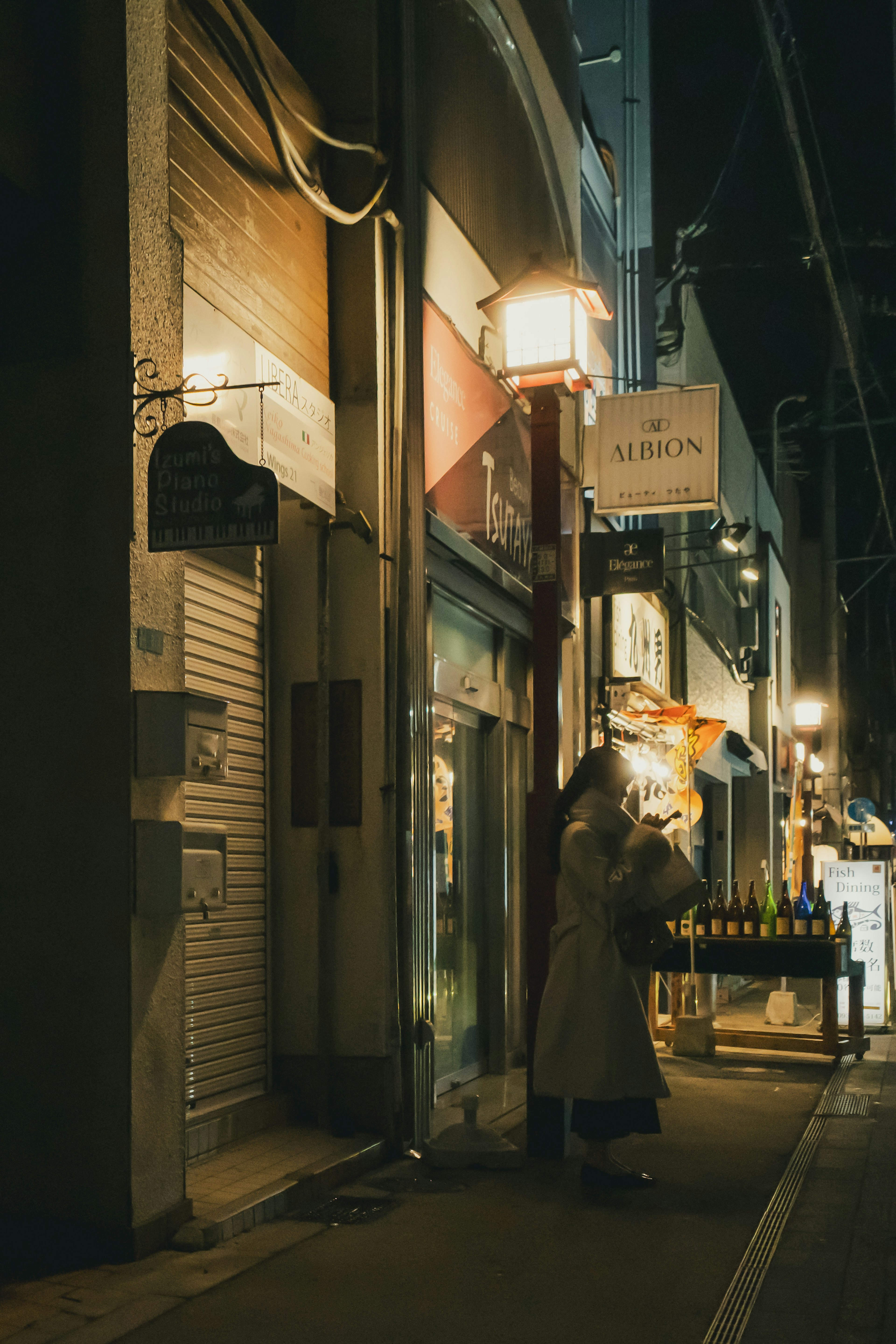 夜晚一家商店前站着一个人的街景
