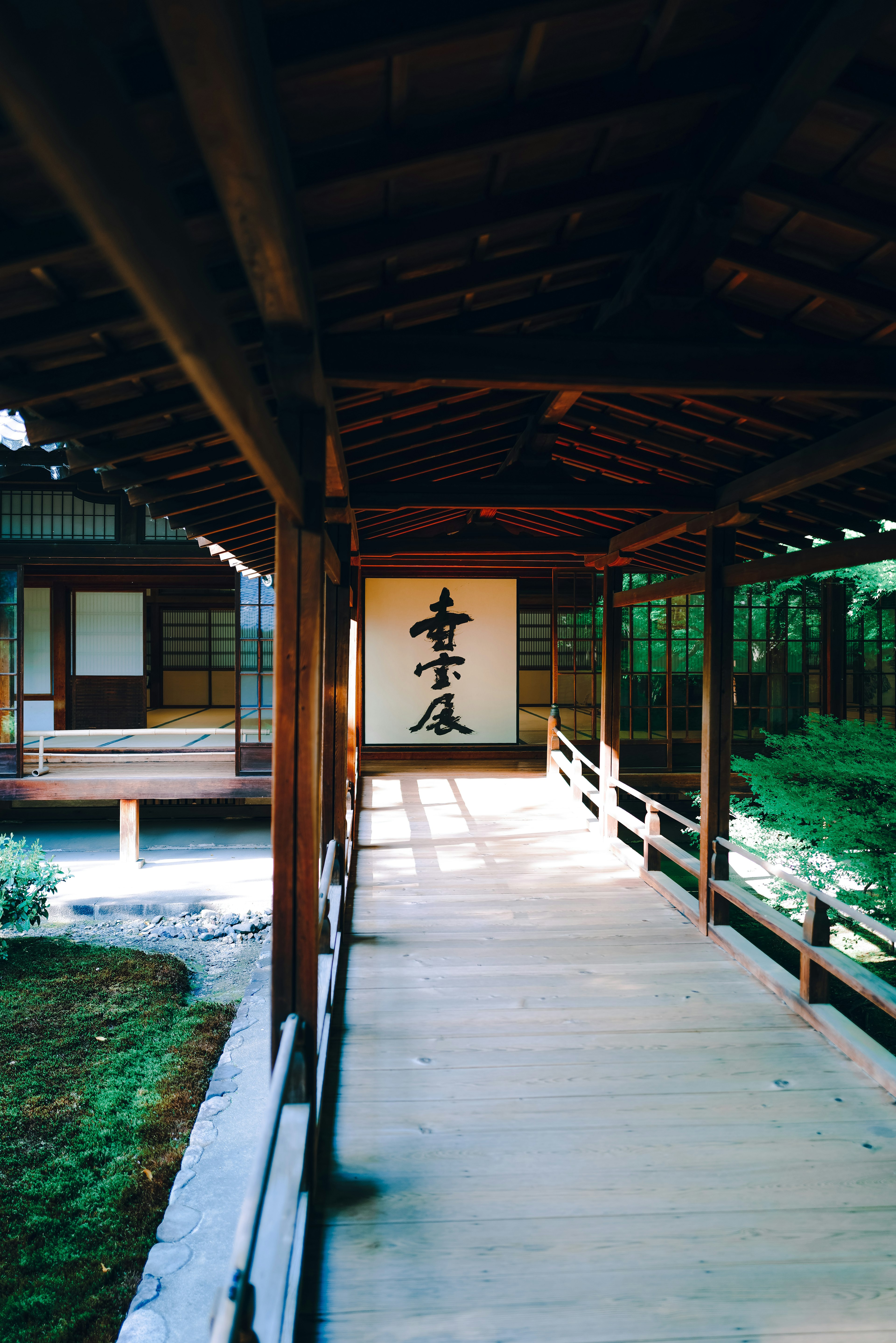 木製走廊與書法卷軸及寧靜花園景觀