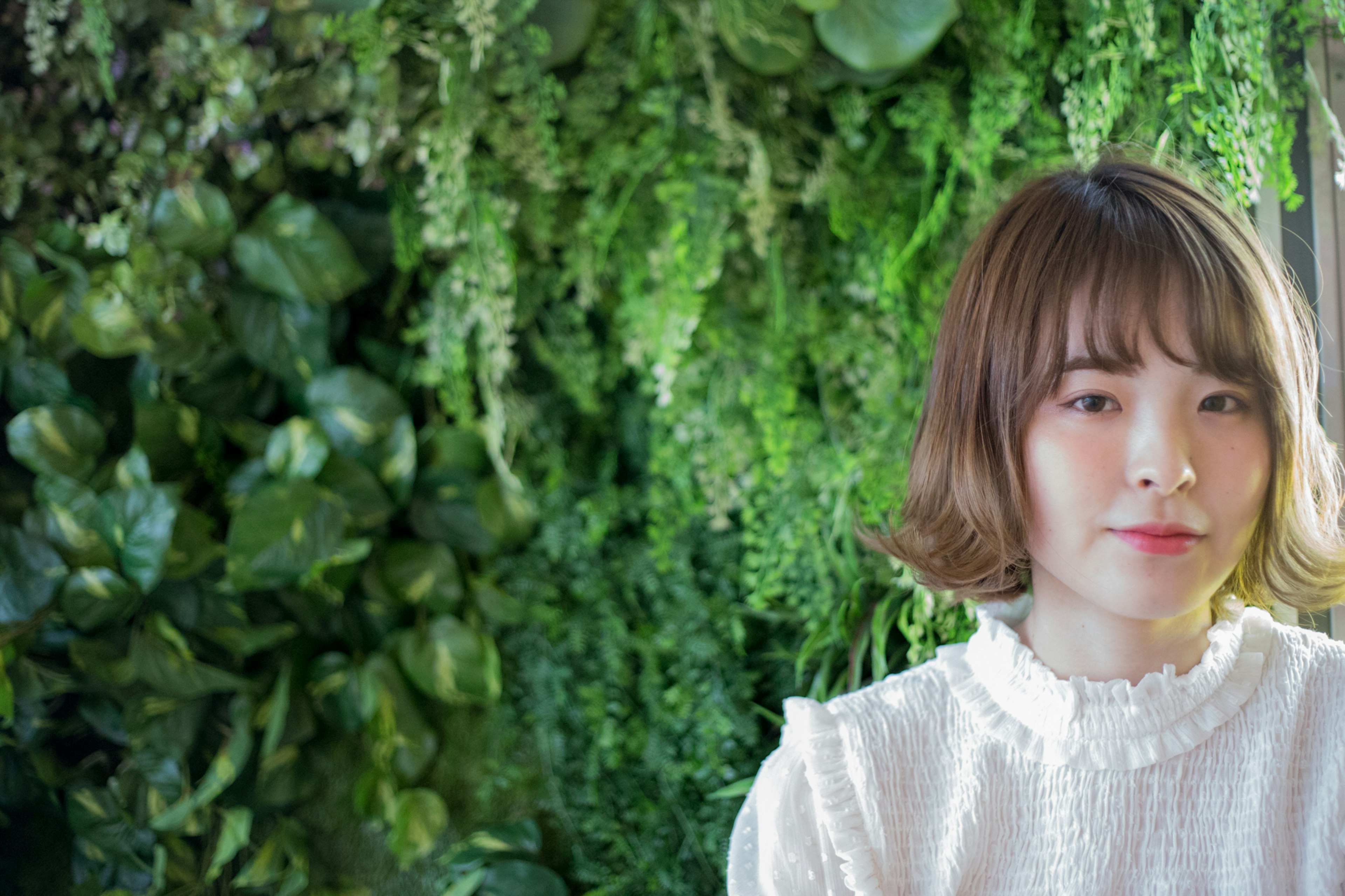 Retrato de una mujer con un fondo de plantas verdes