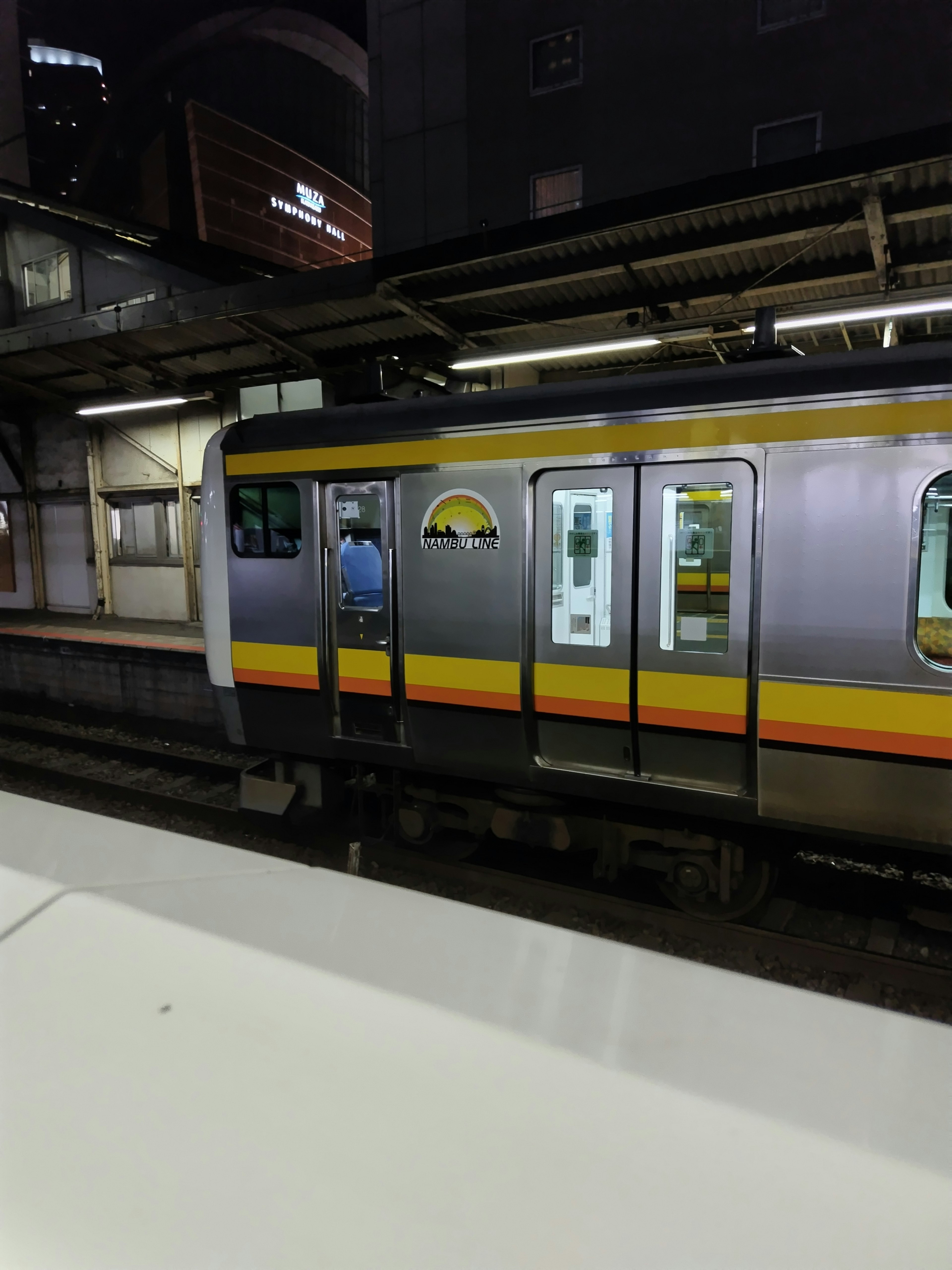 Vista lateral de un tren detenido en una estación por la noche