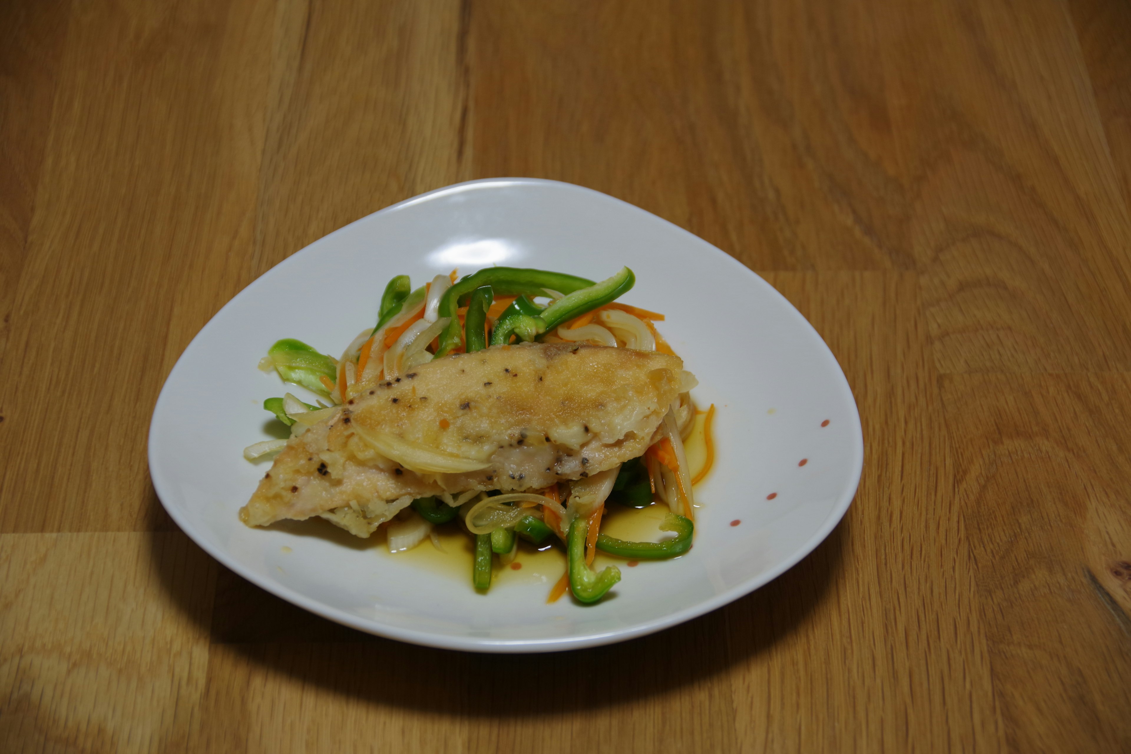 Plat de poulet et légumes servi dans une assiette blanche