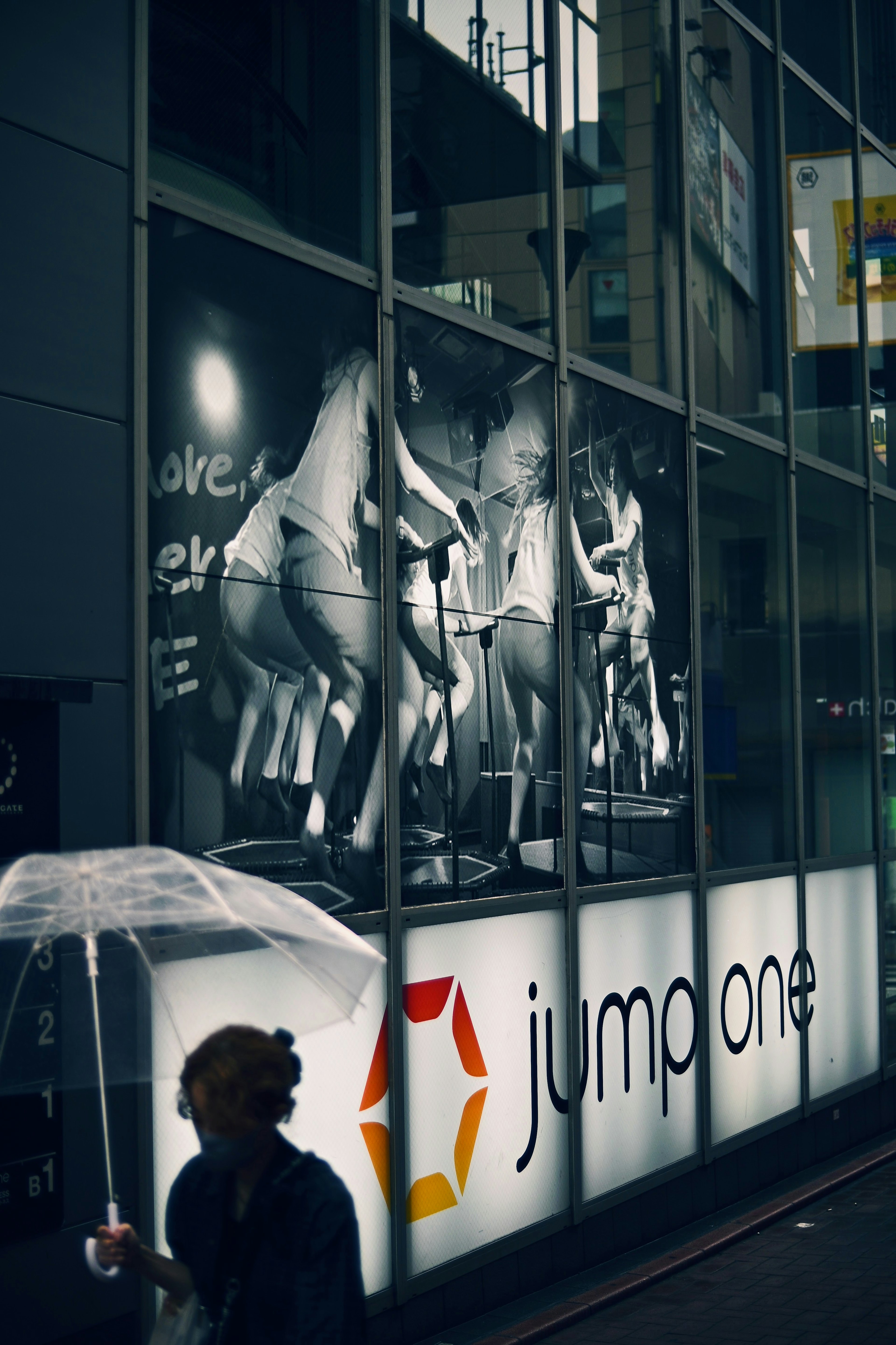 Fenêtre de gym affichant des activités de fitness avec une personne tenant un parapluie