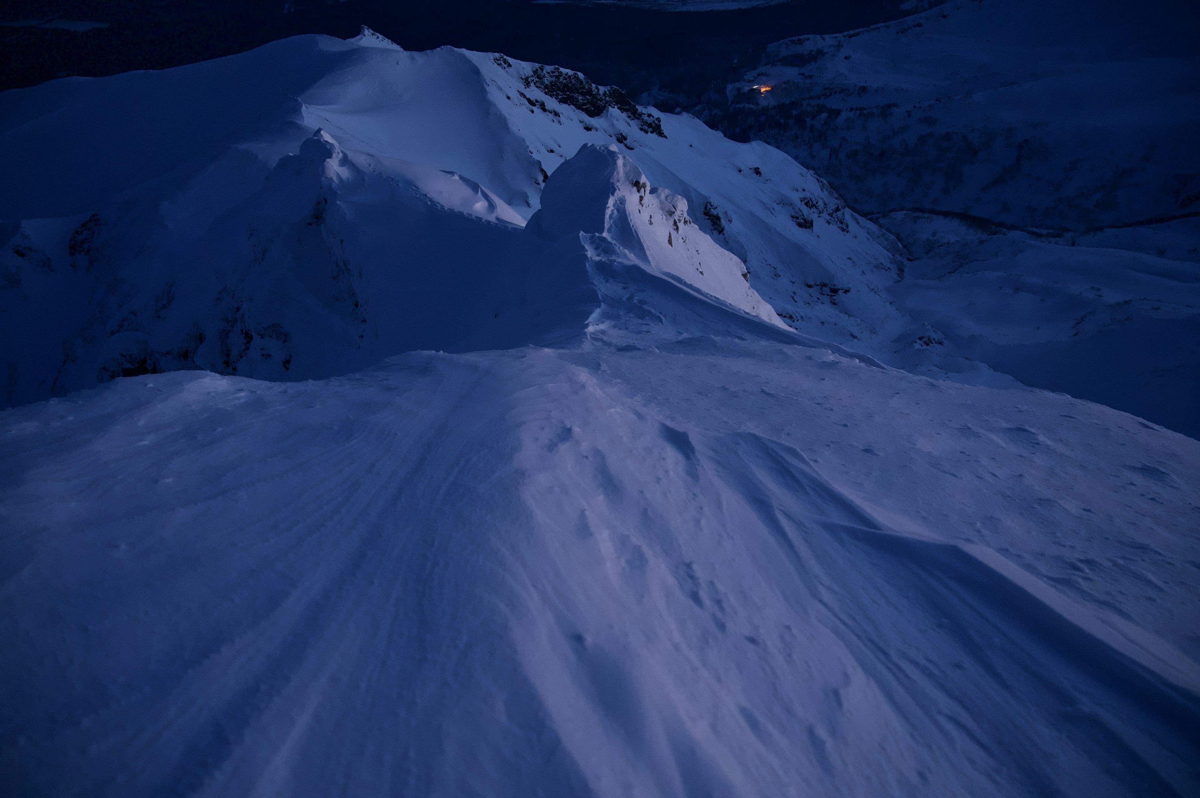 Nachtansicht eines schneebedeckten Berges mit sanften Kurven