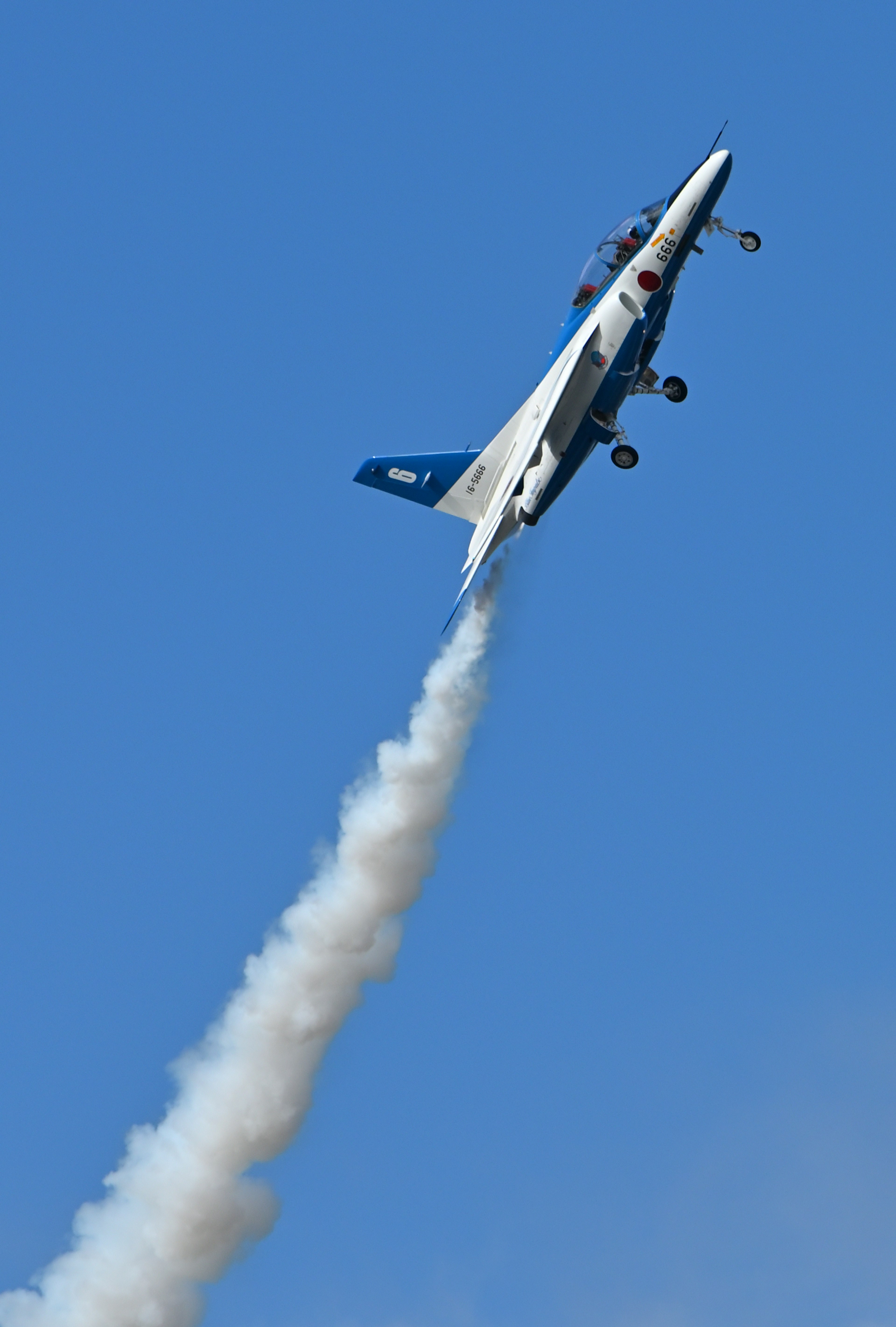 Bild eines Flugzeugs, das steil gegen einen blauen Himmel aufsteigt