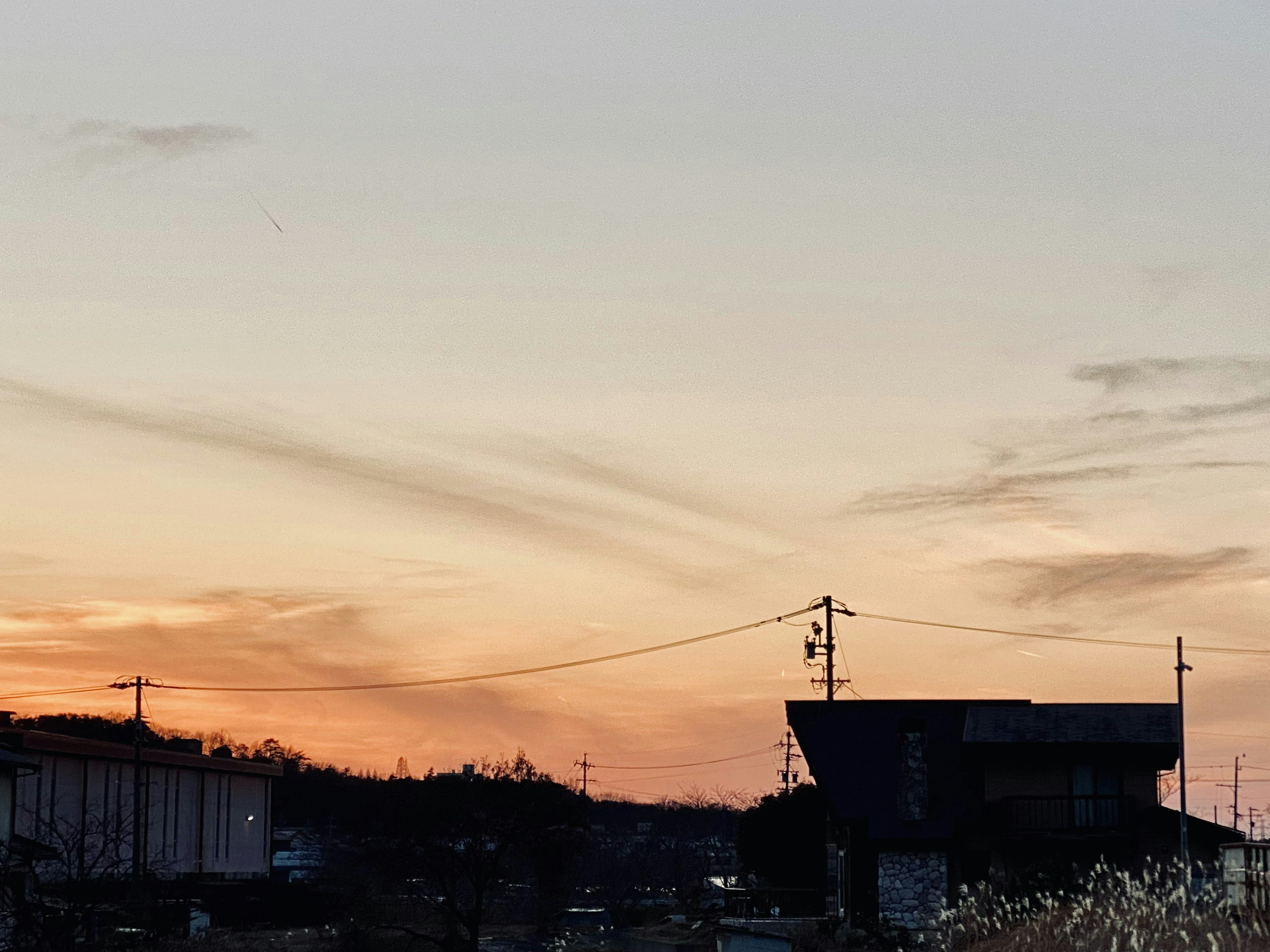 Edifici in silhouette e pali della luce contro un cielo al tramonto