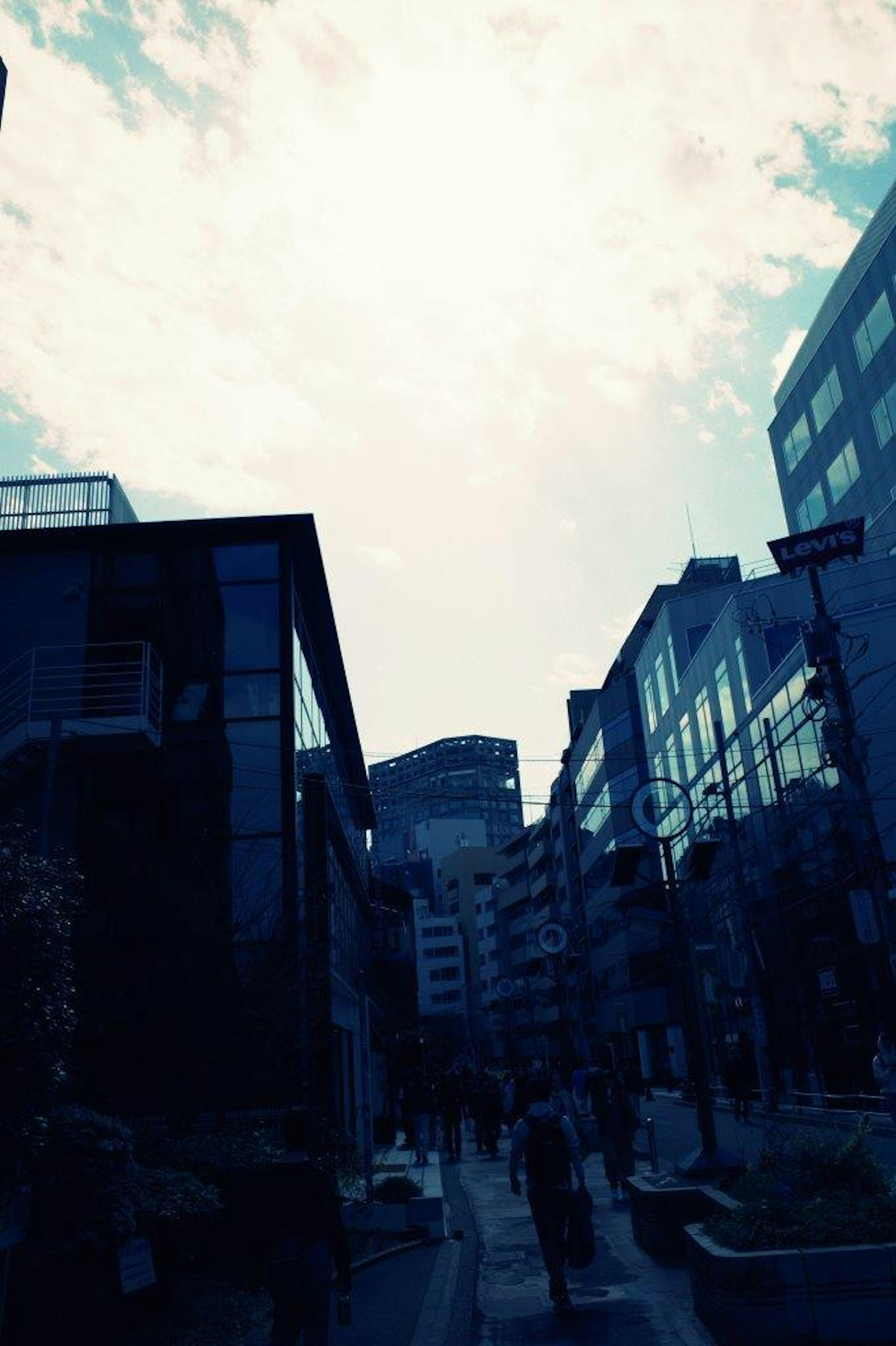 青いトーンの都市の街並みと雲のある空