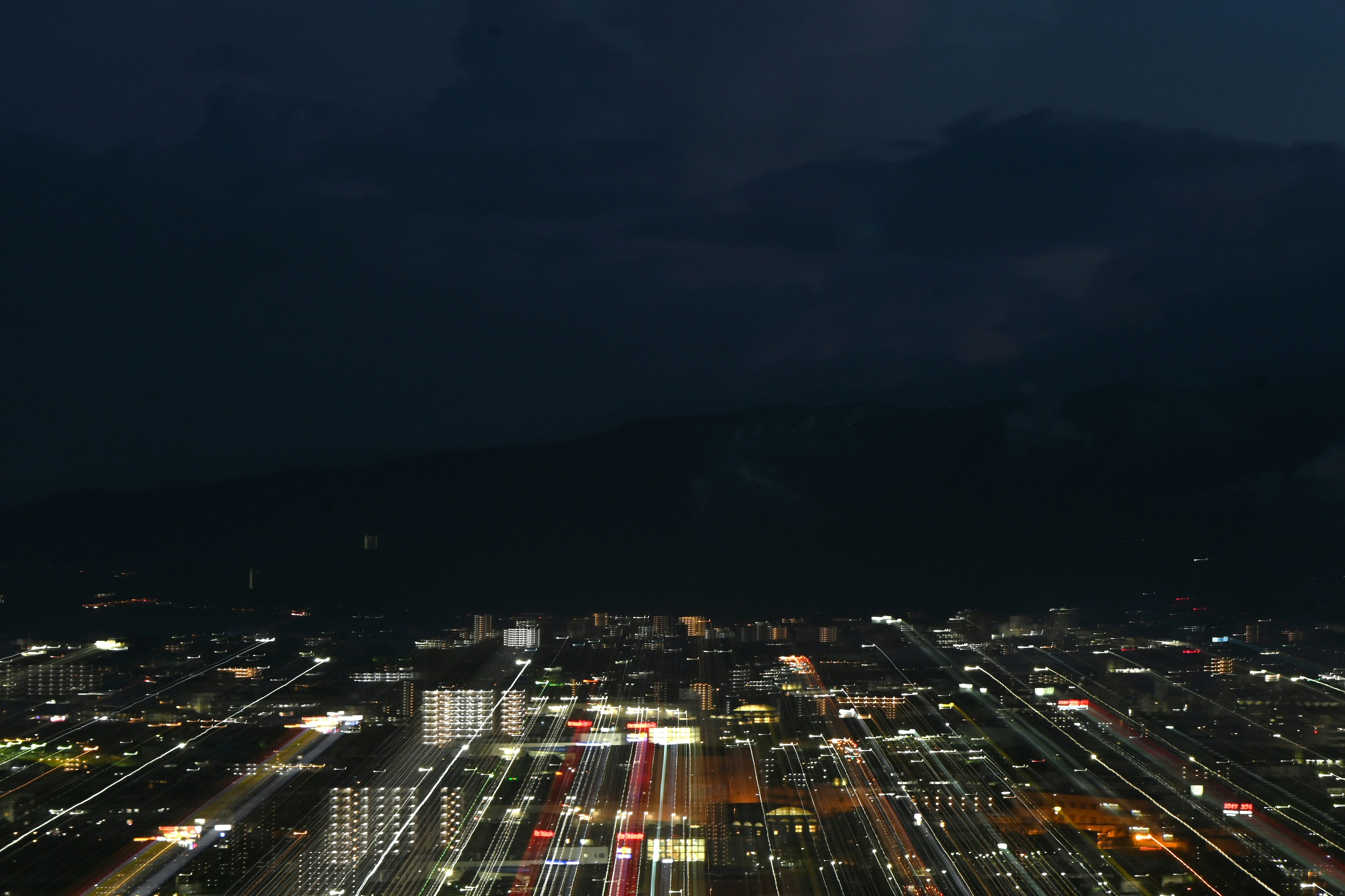 夜の都市の全景 輝く光と動きのある車の流れ