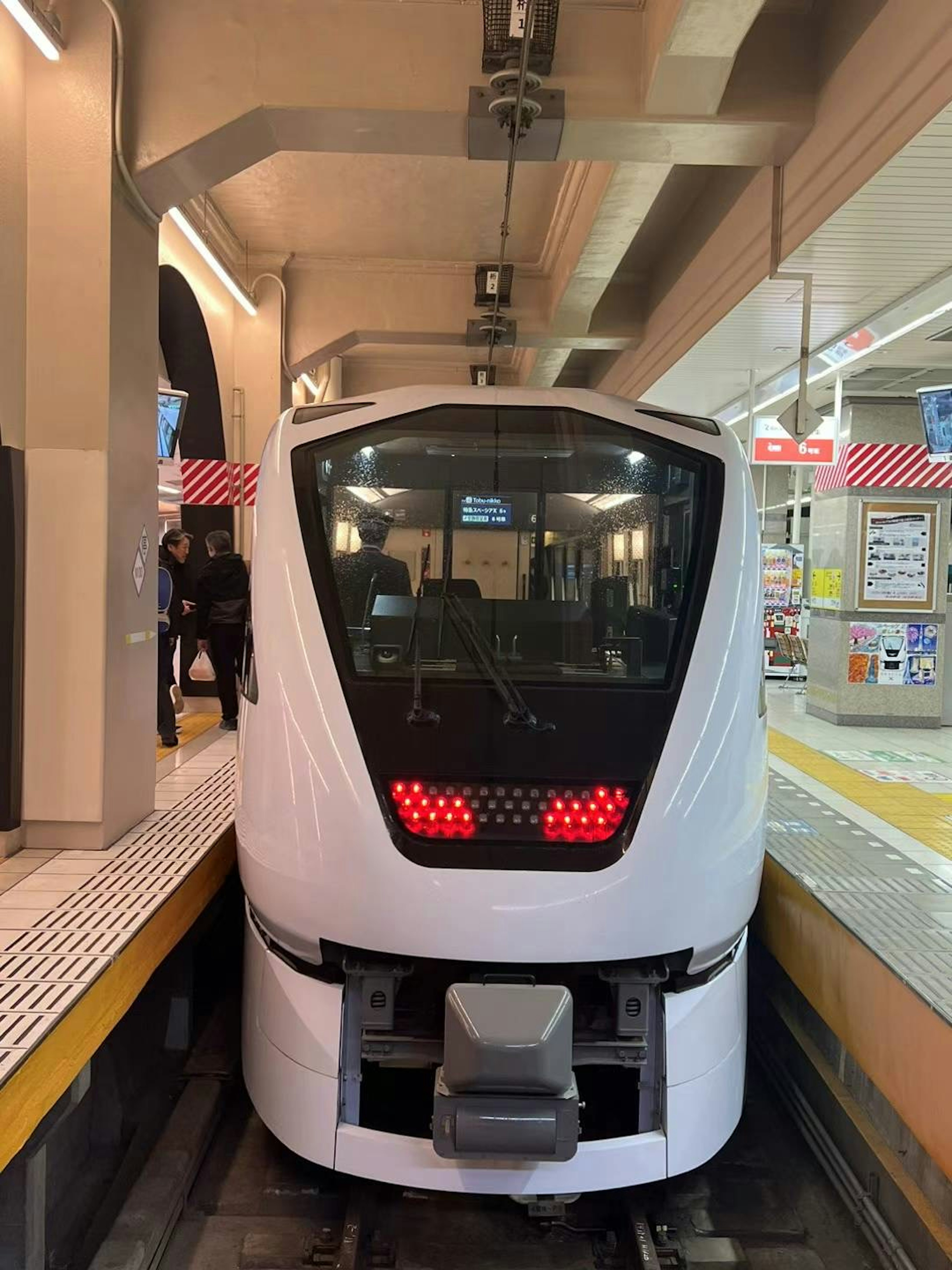 Front view of a white train stopped at a station