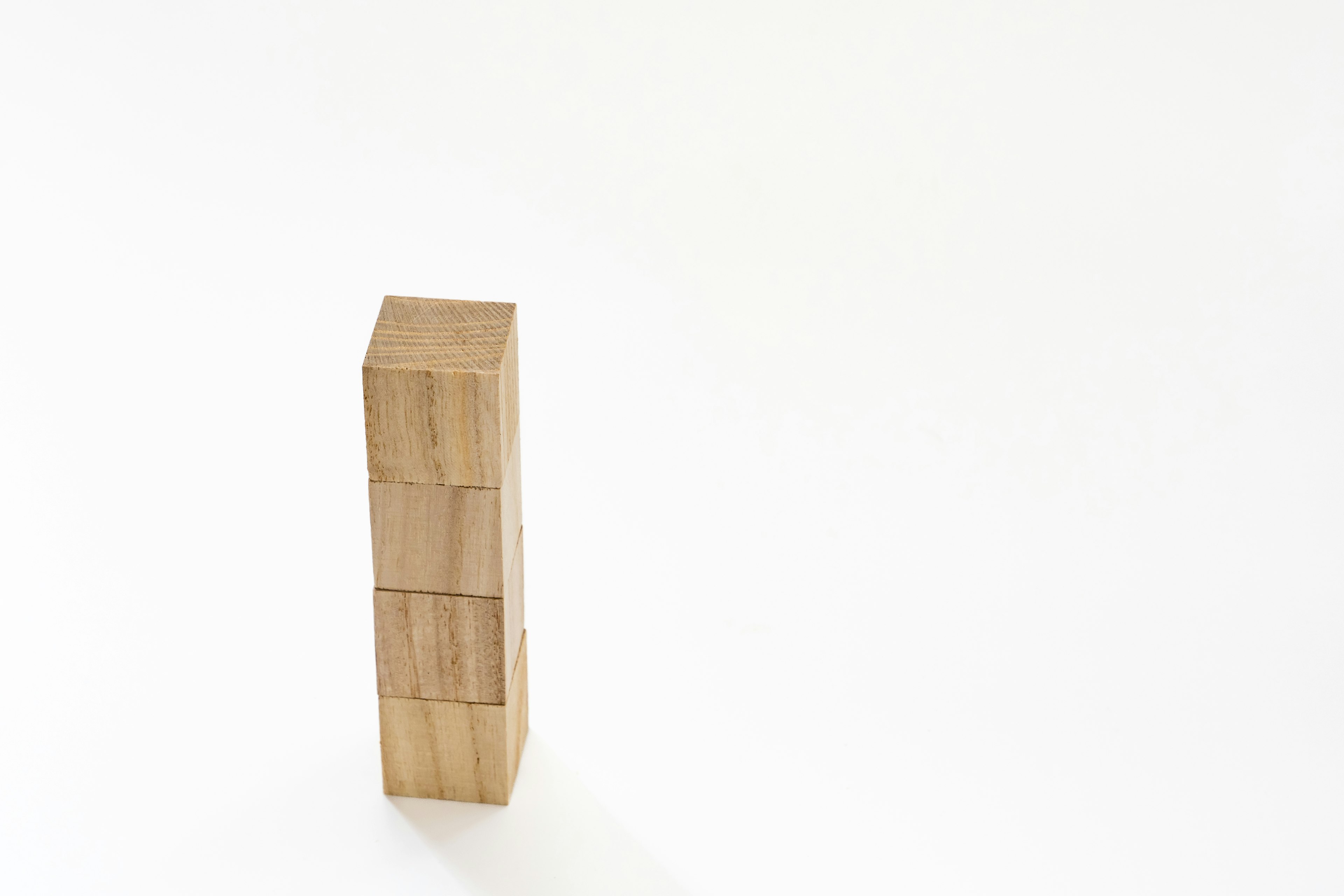 A wooden block tower stands against a white background