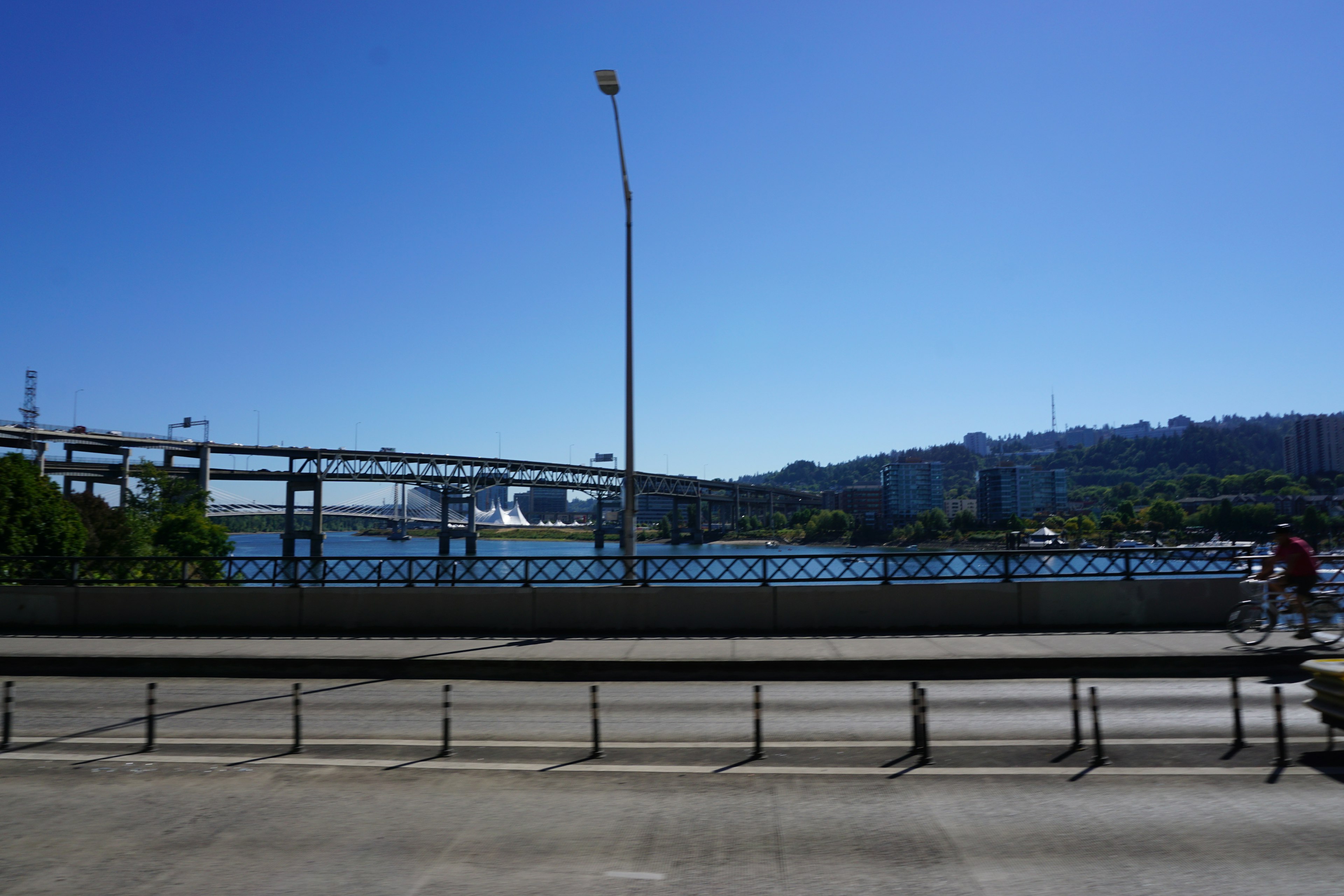 风景优美的蓝天和河流骑自行车的人在路上桥和城市风景