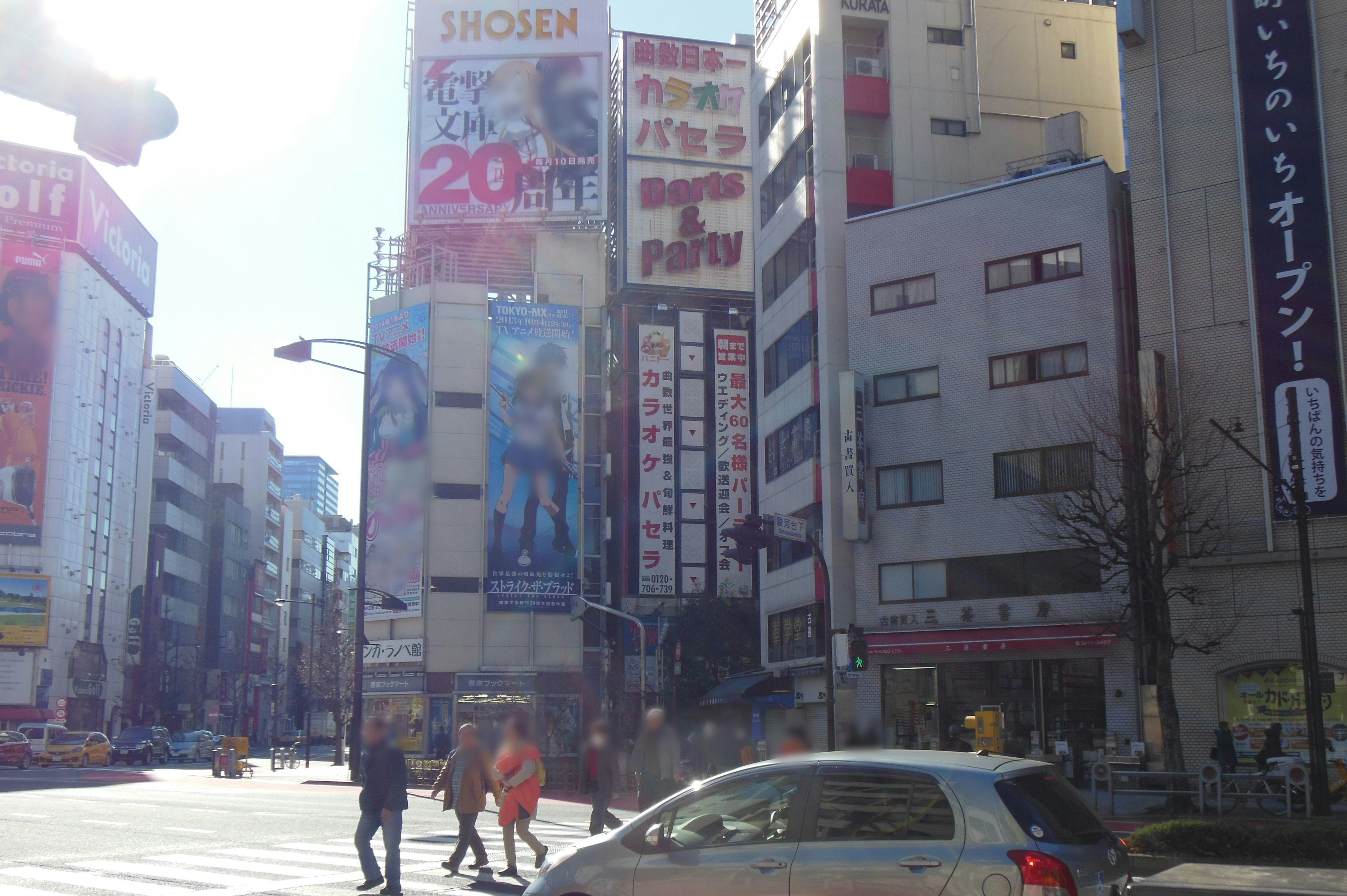 Busy urban scene featuring tall buildings and prominent advertisements at an intersection