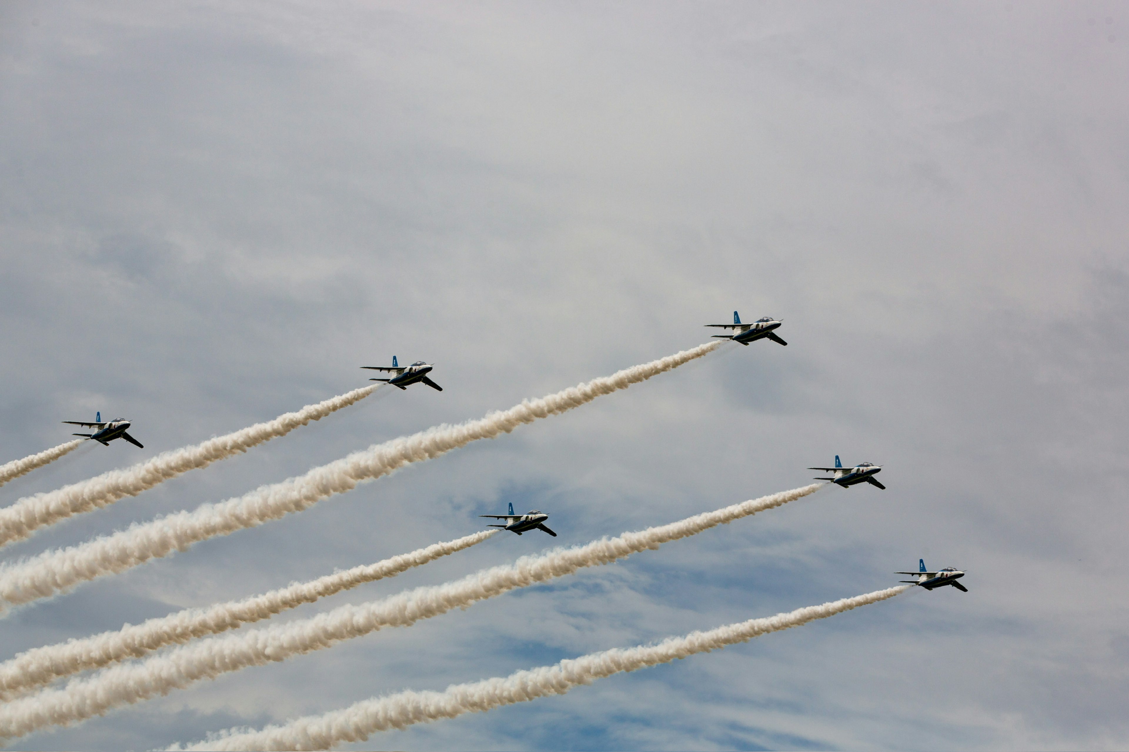 Flugzeugformation mit weißen Rauchspuren