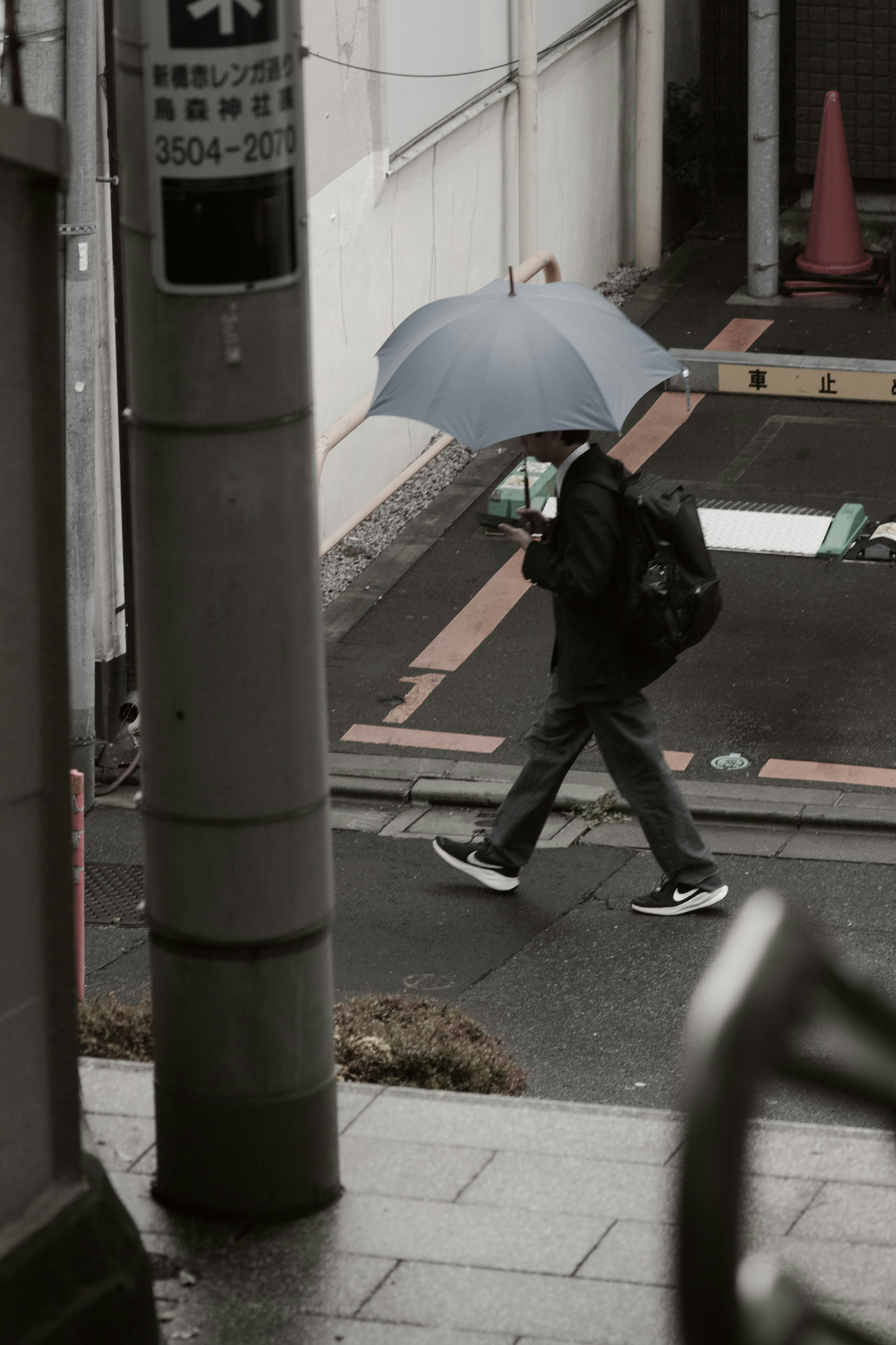 傘を持って歩く人が写っている街の風景