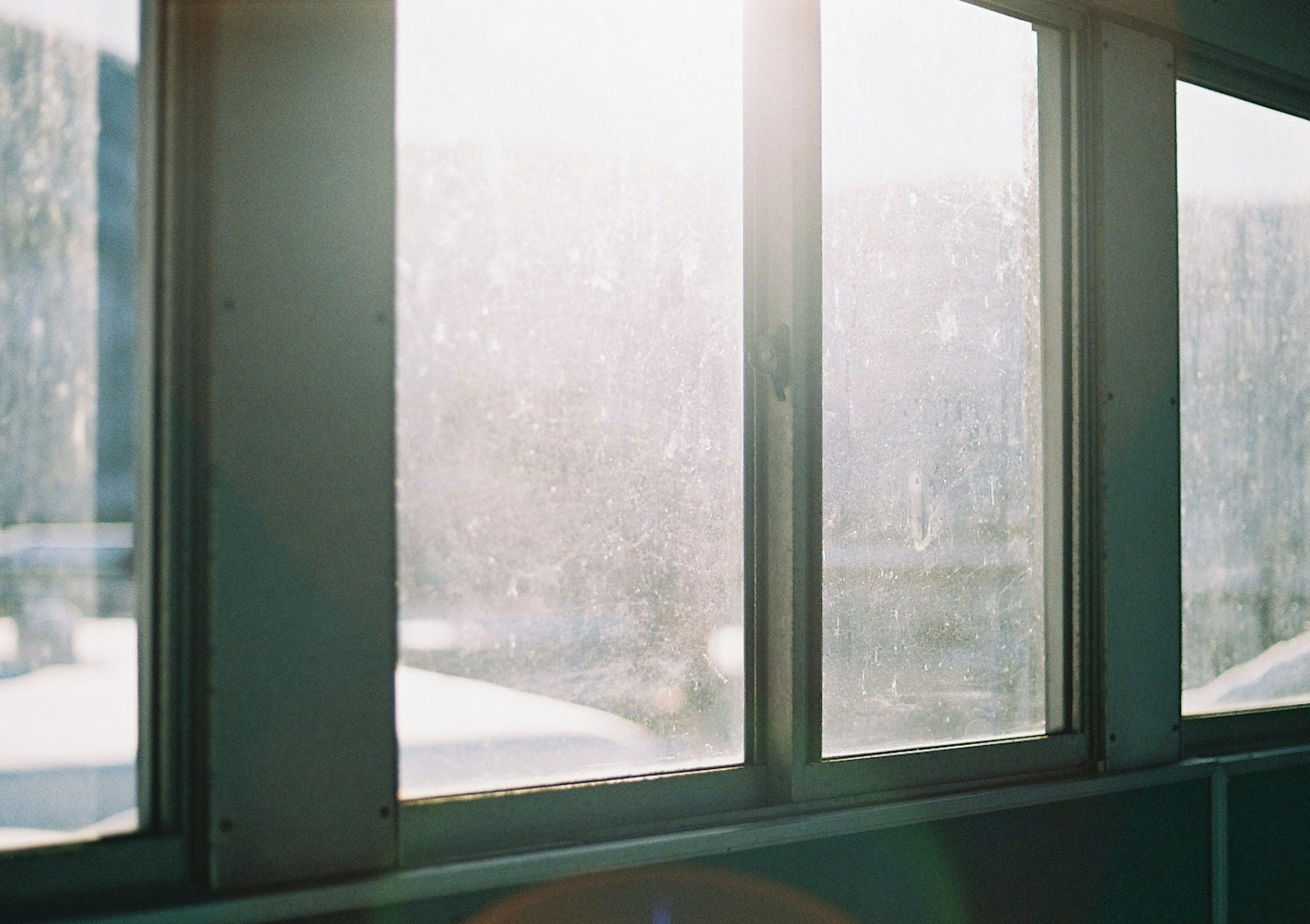 Sunlight streaming through foggy windows with an outdoor view