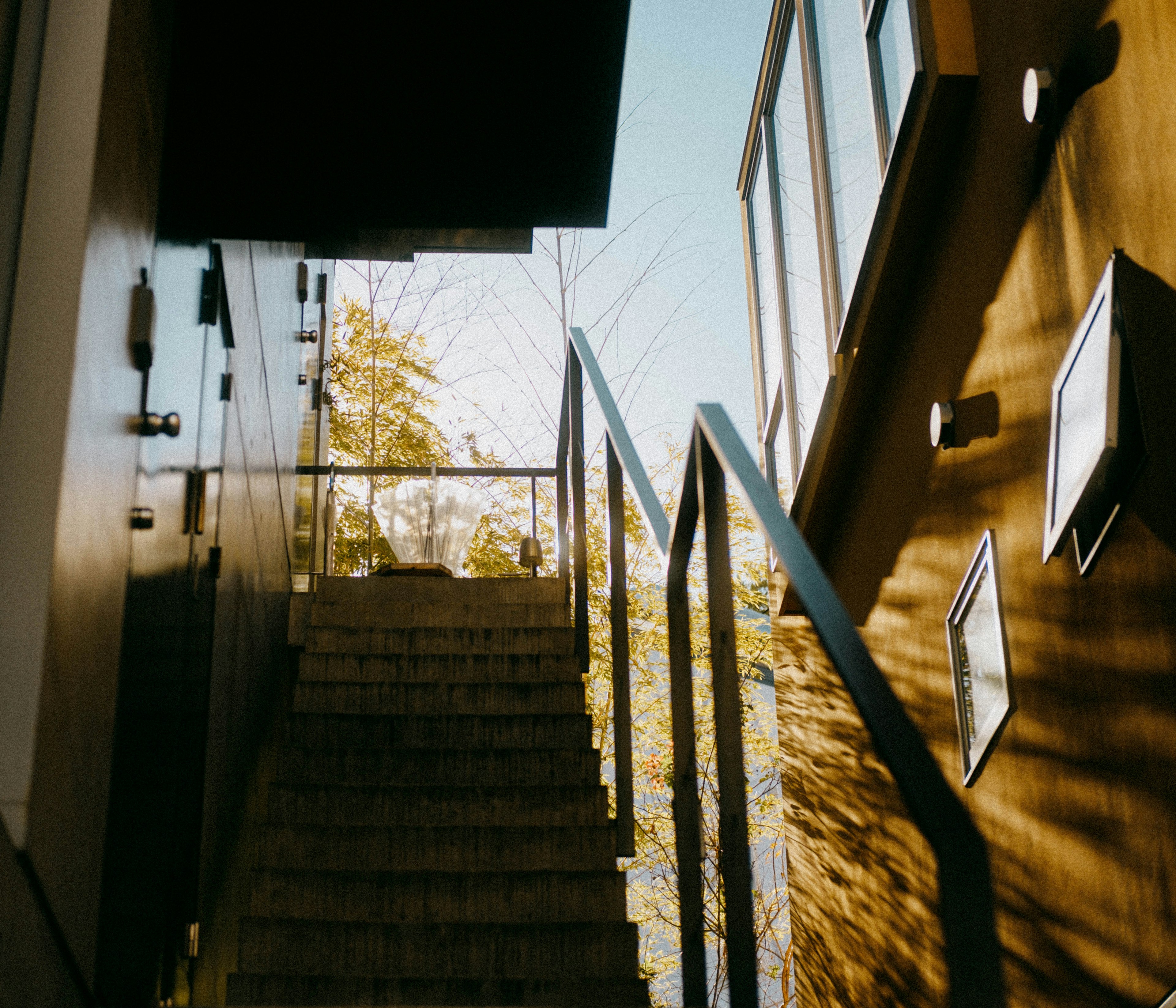 Foto von Treppen und Gebäudeseite mit hellem Himmel und natürlichem Licht in einem schlichten Design