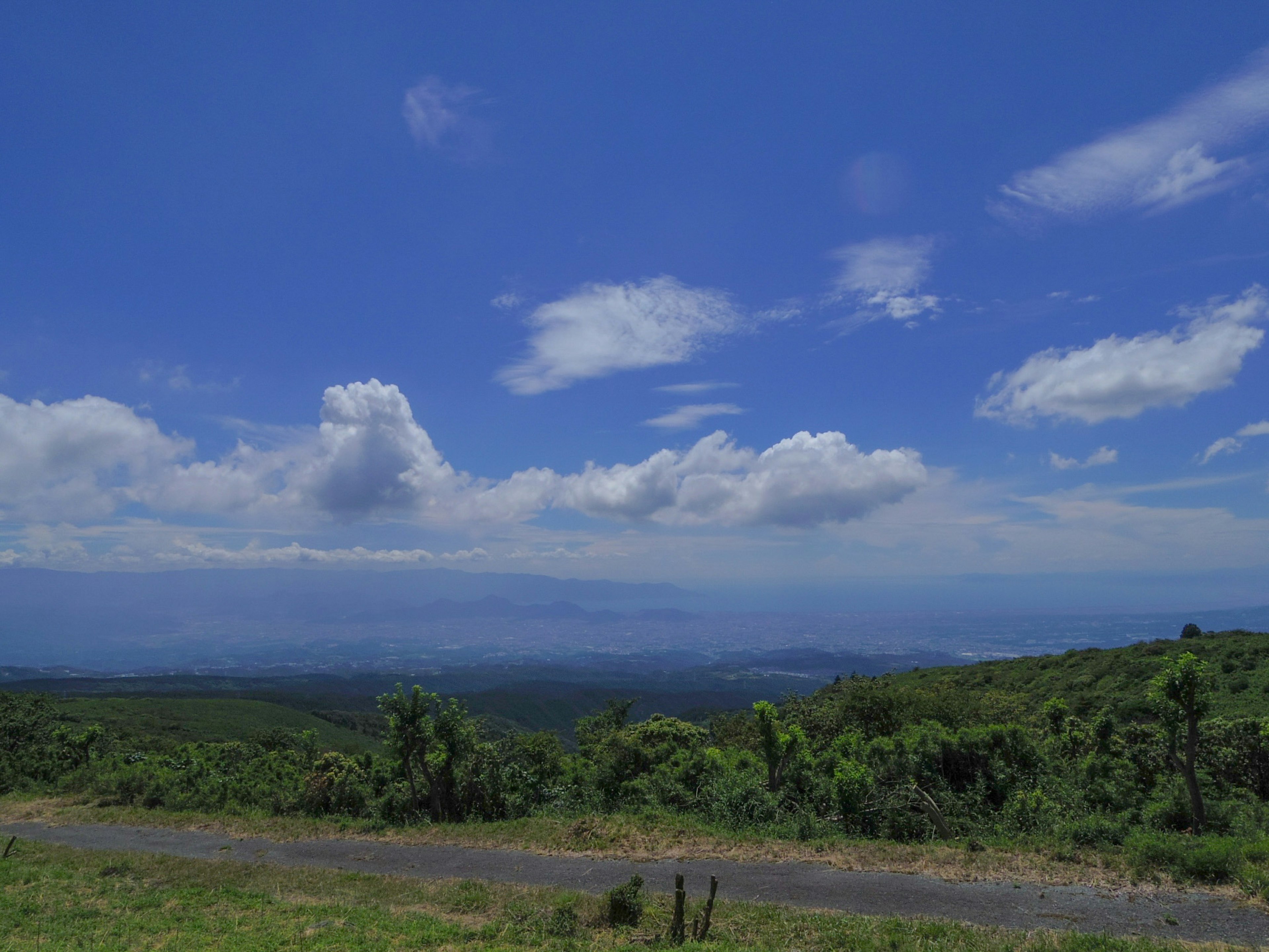 美麗的風景 藍天和白雲 綠色山丘和一條道路